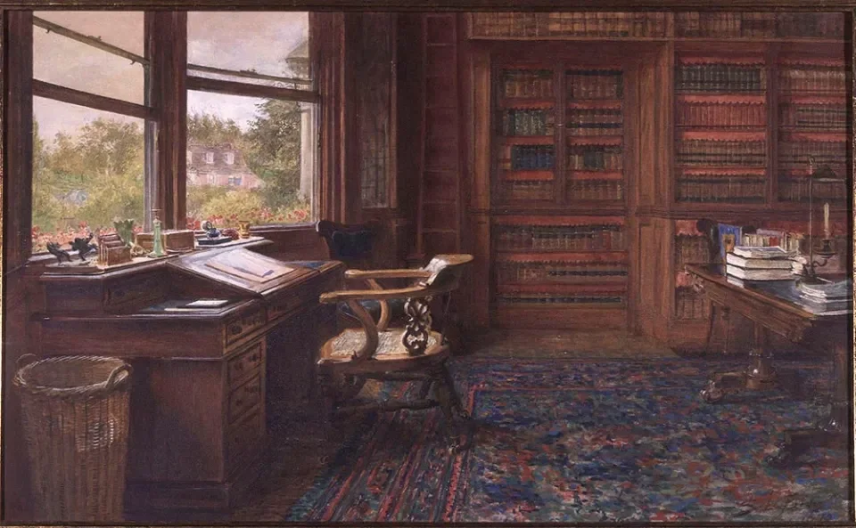 A cozy study room with a large window showing a garden outside. There is a wooden desk with papers, a glass bottle, and a lamp. An ornate wooden chair is in front of the desk. The room has built-in bookshelves filled with books and a wooden table with stacks of books and papers. A colorful patterned rug covers the floor.