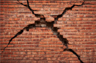 Cracked brick wall with large fractures