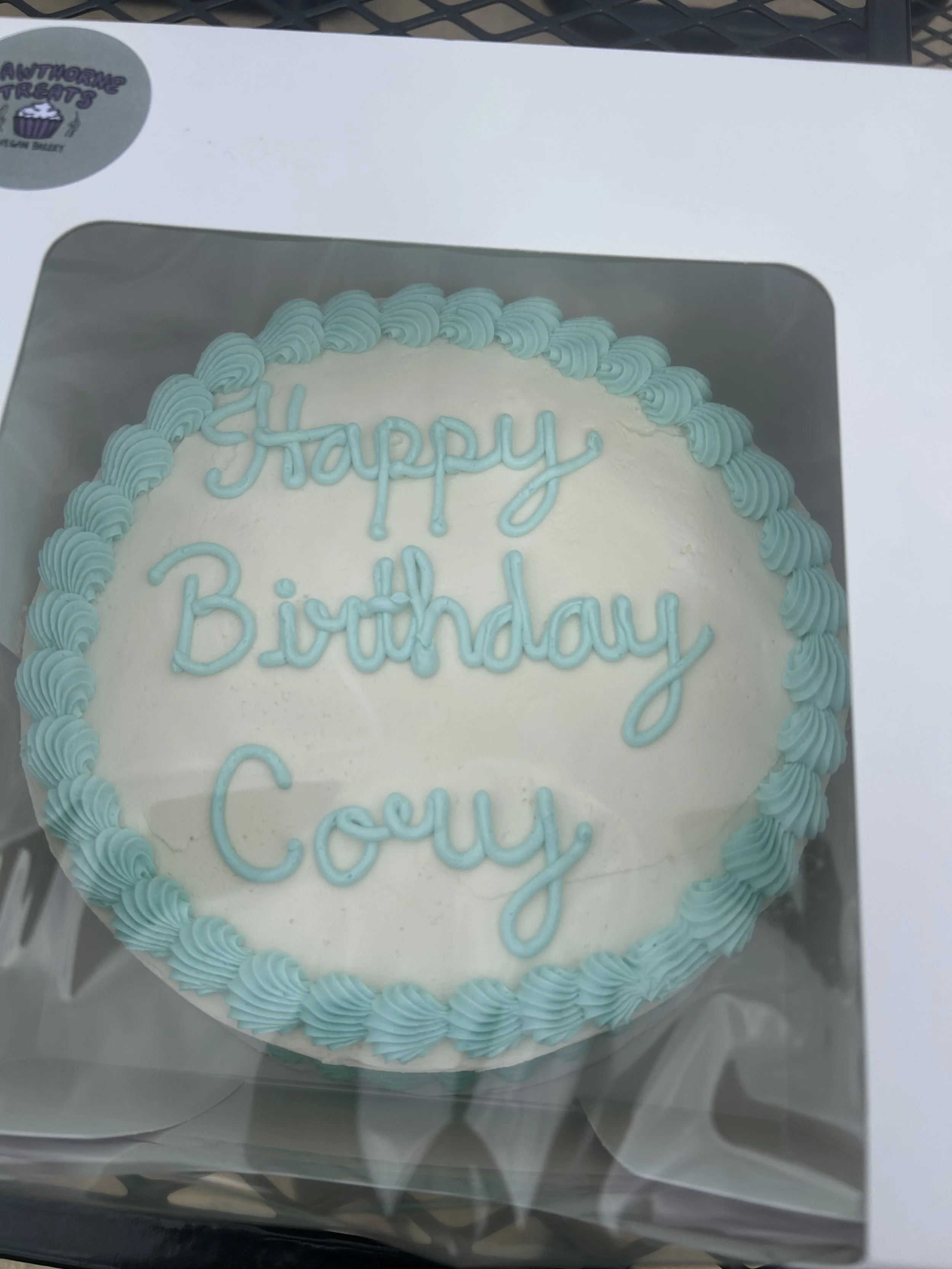 custom birthday cake with light blue decorations. vanilla cake and buttercream with strawberry filling. 