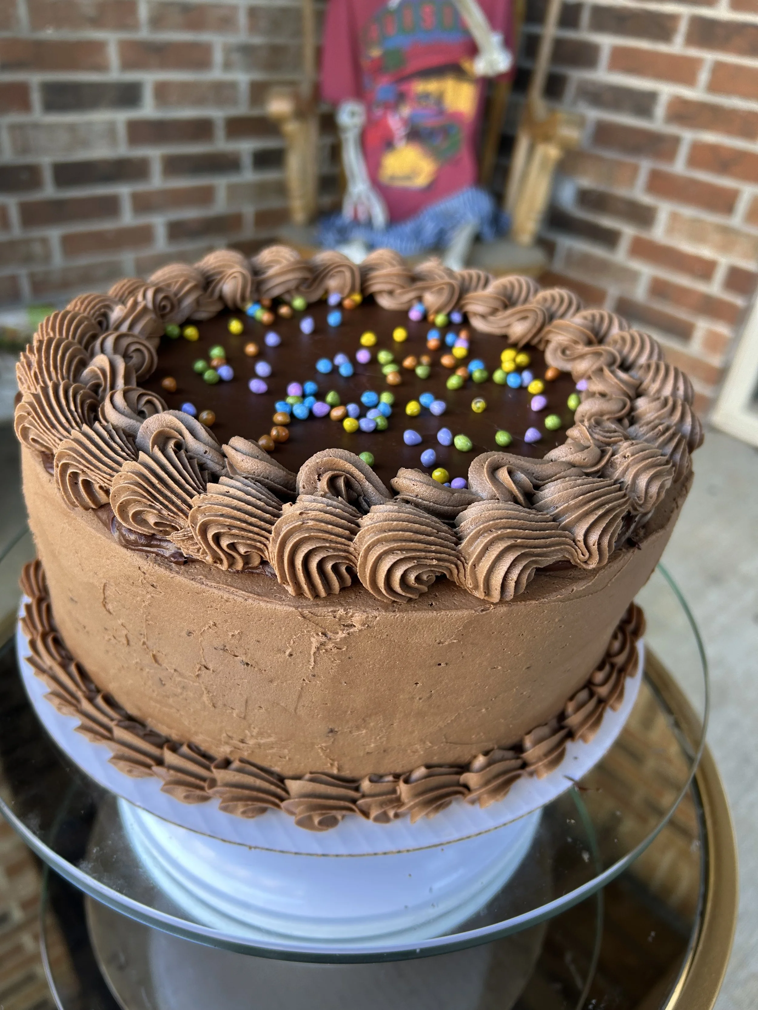 galaxy brownie cake. two layers of chocolate cake and buttercream with a chocolate ganache and sprinkle covered brownie in the middle and more ganache and sprinkles on top. rich and decadent.
