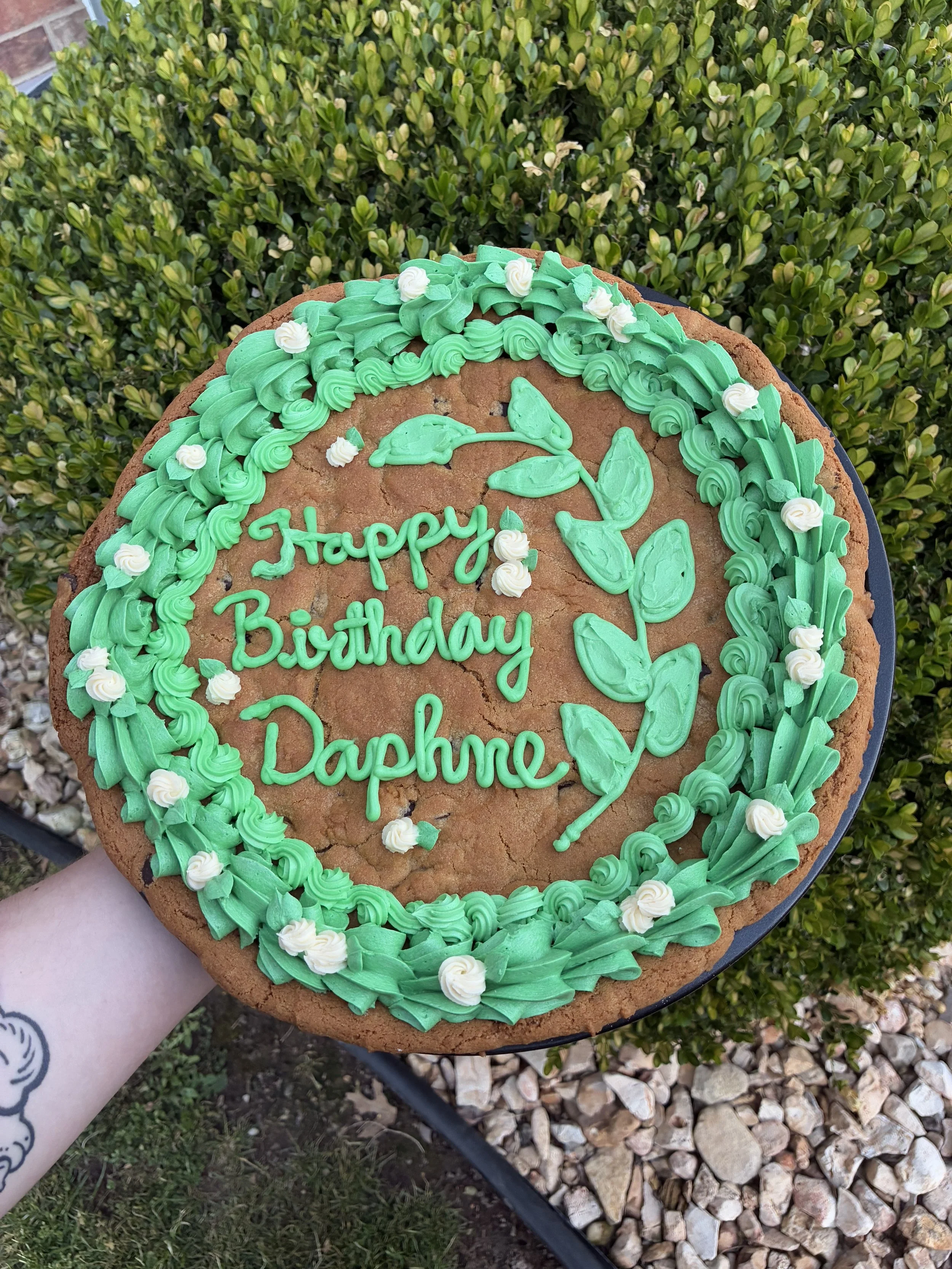cookie cake with custom whimsical greenery .
