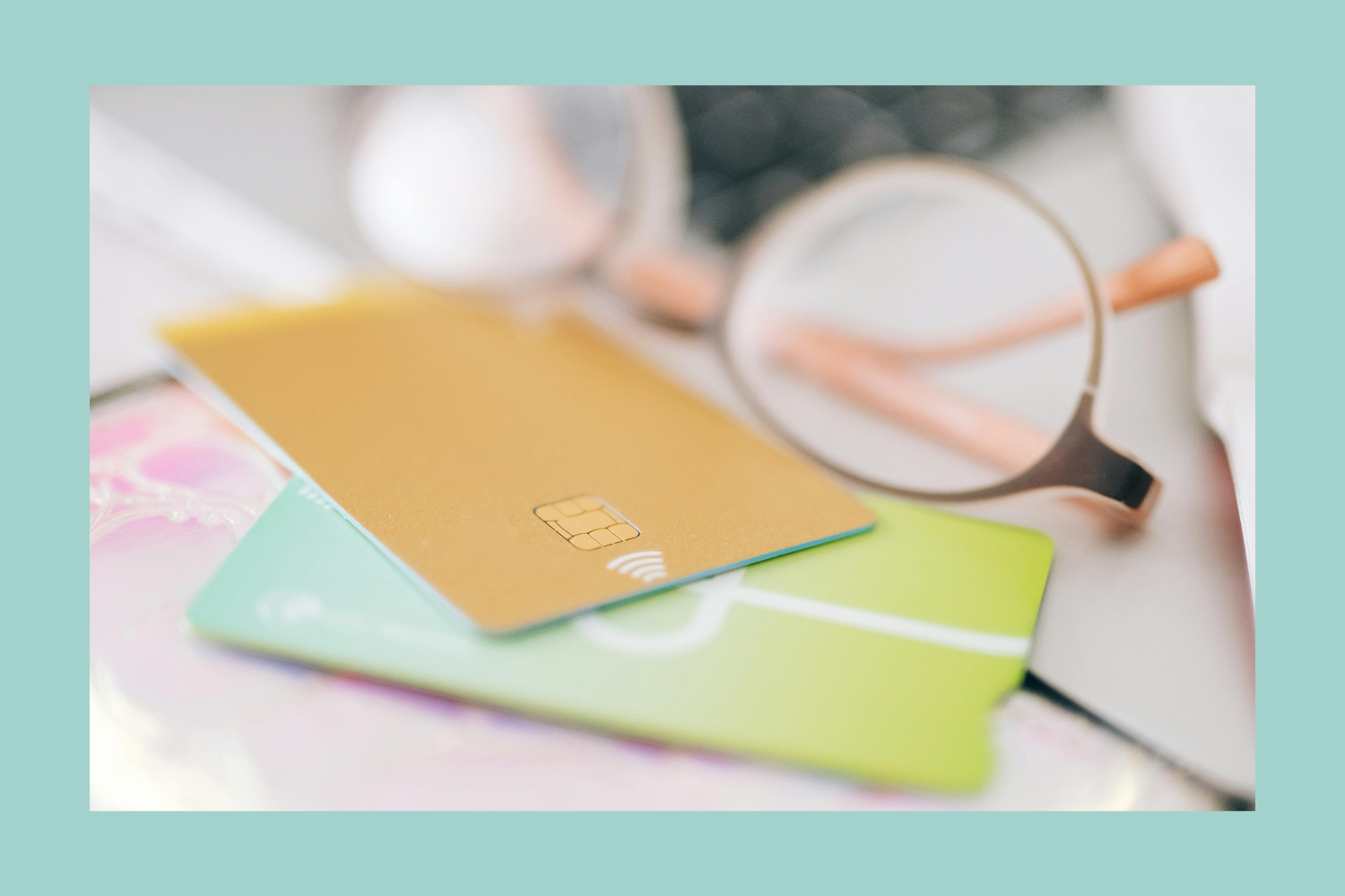 Close-up of colorful credit cards and eyeglasses on a table.