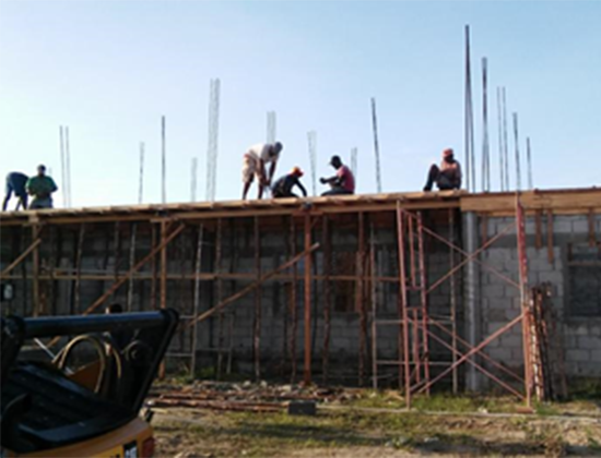 Construction workers working on a building under construction, with scaffolding and exposed rebar in the background.