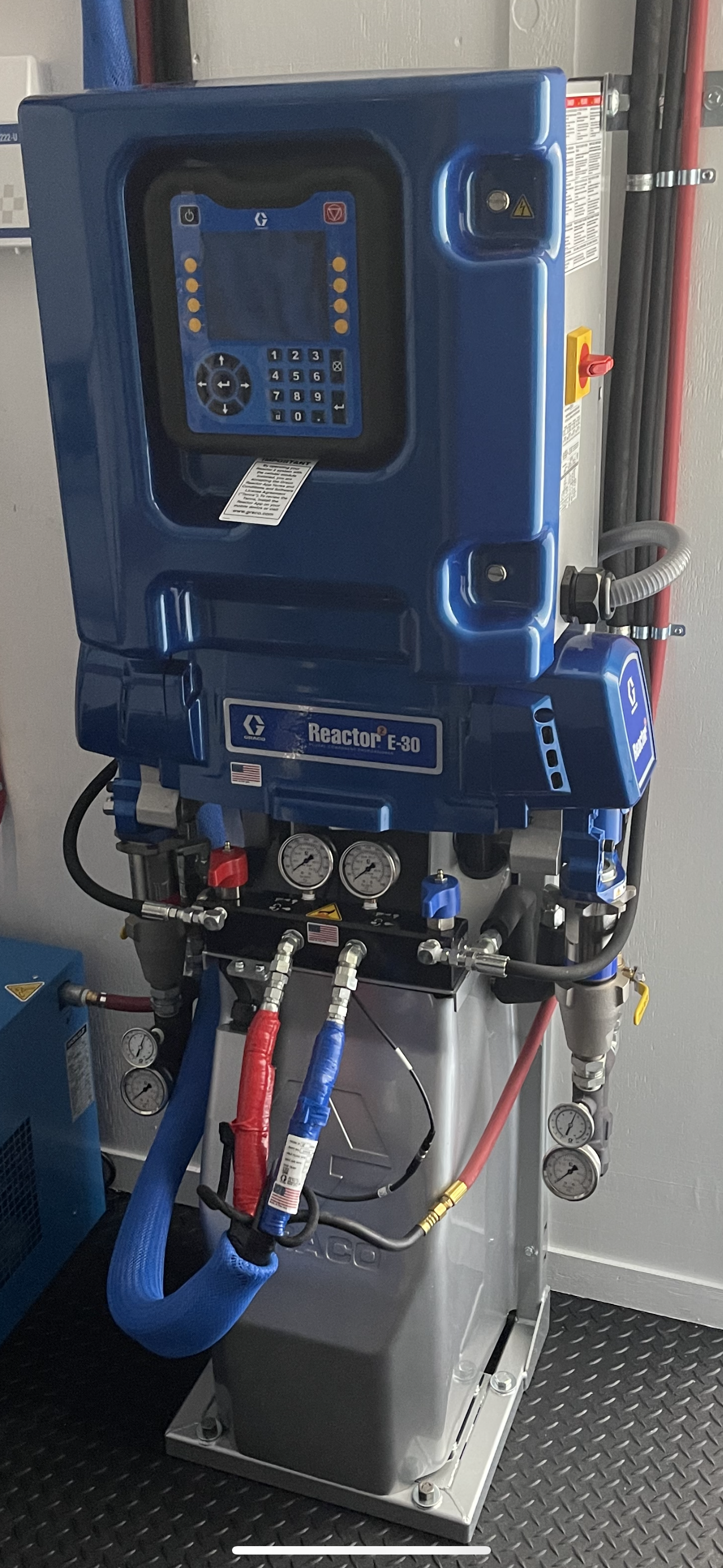 Industrial machine labeled Reactor E-30 with gauges, hoses, and control panel.