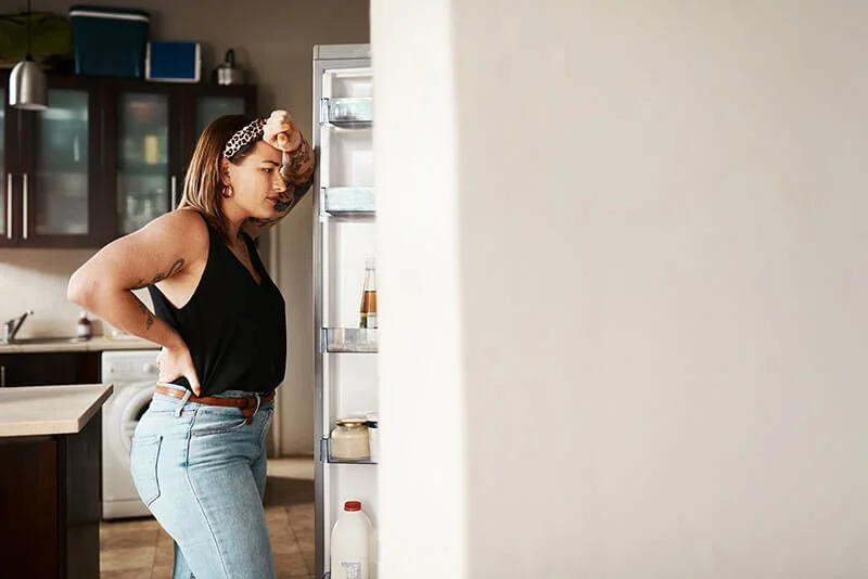 woman looking in refrigerator
