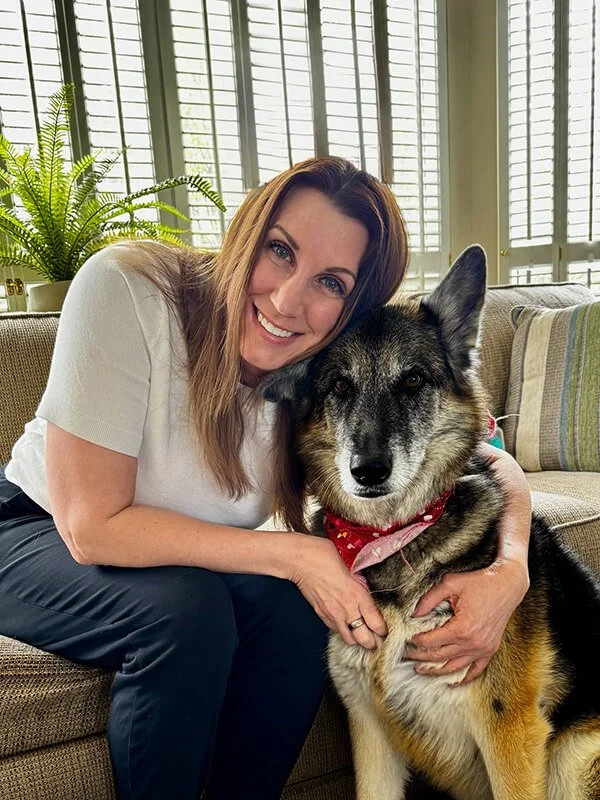 Dr. Tammy Root, eating disorder therapist, hugging her dog.