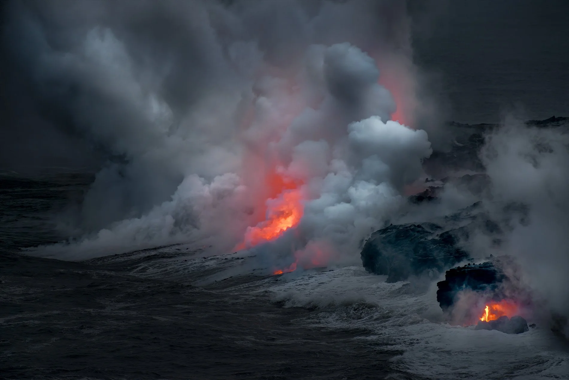 Ocean waves crashing with visible lava and smoke, indicating a volcanic eruption at sea.