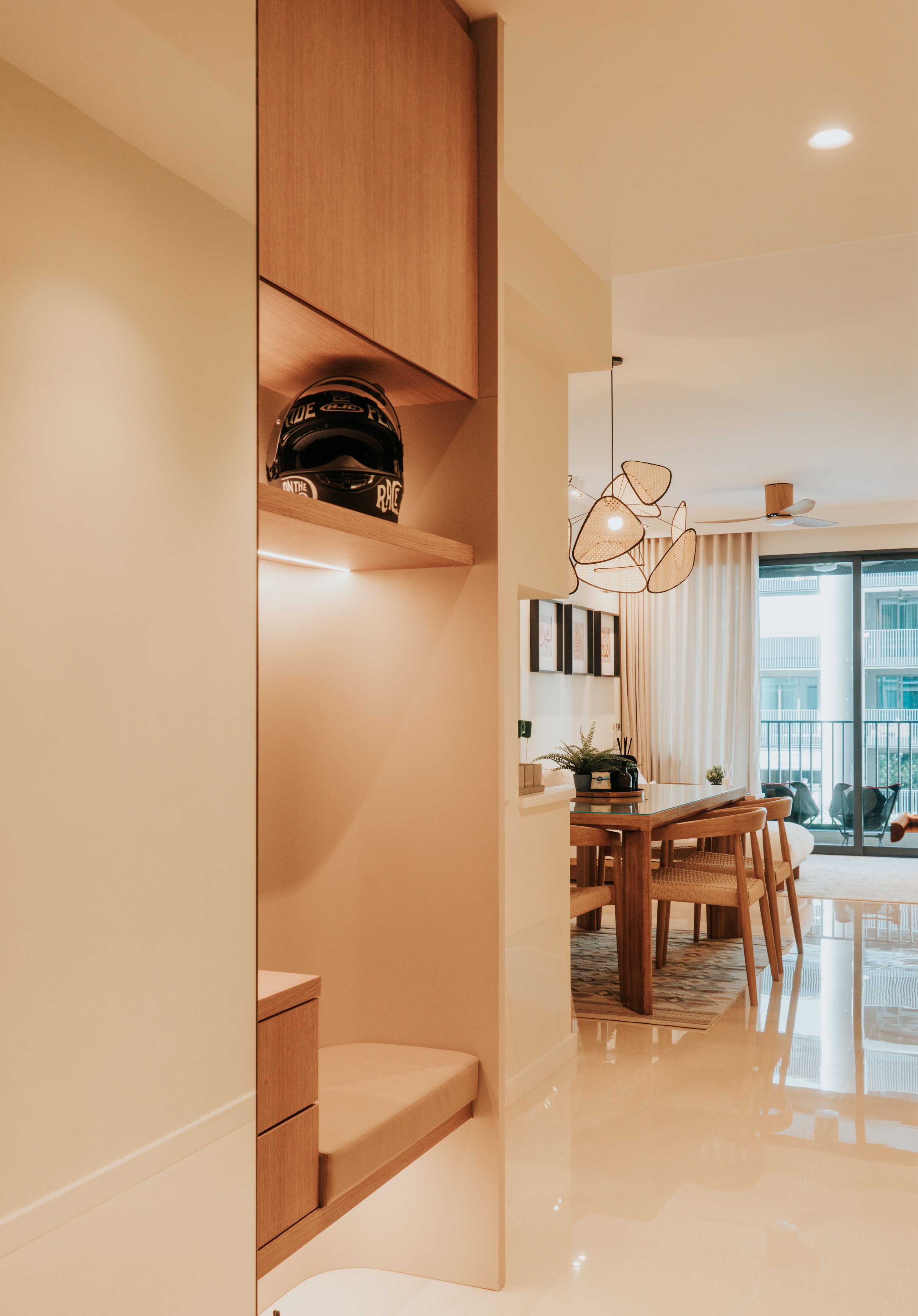 Modern living room with dining area, large glass balcony doors, and artistic pendant lights.