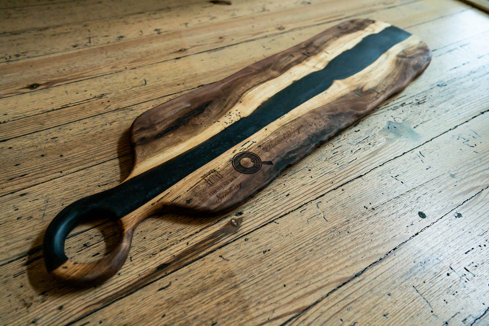 A wooden serving tray, featuring walnut and black epoxy