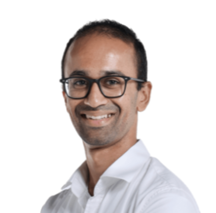 Portrait of a man wearing glasses and a white collared shirt, smiling against a plain white background.