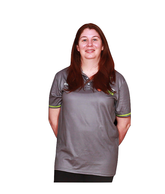 A woman with long red hair standing against a black background, wearing a gray polo shirt with lime green accents.