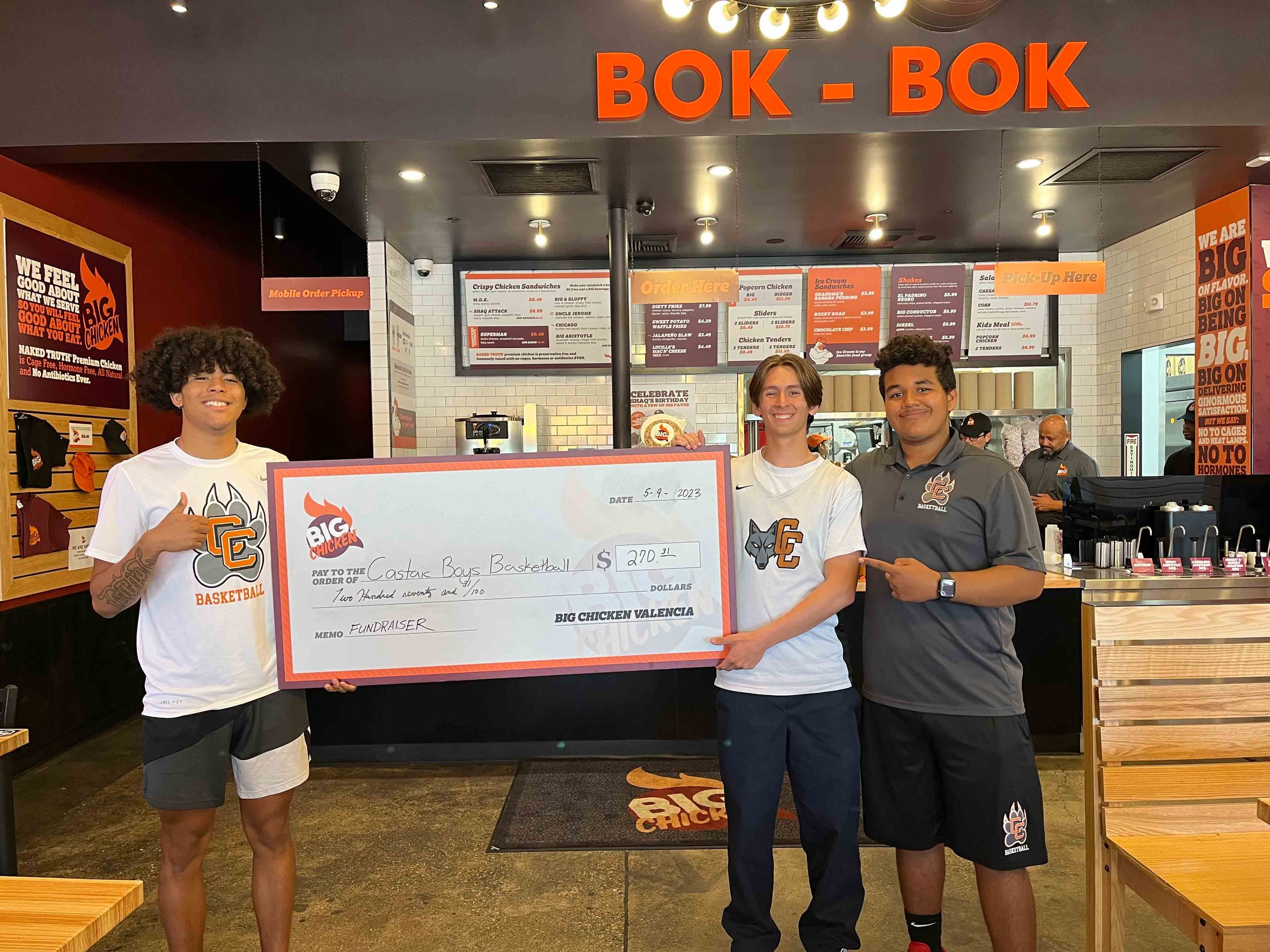 a second photo of Costas Boys Basketball team with oversize check