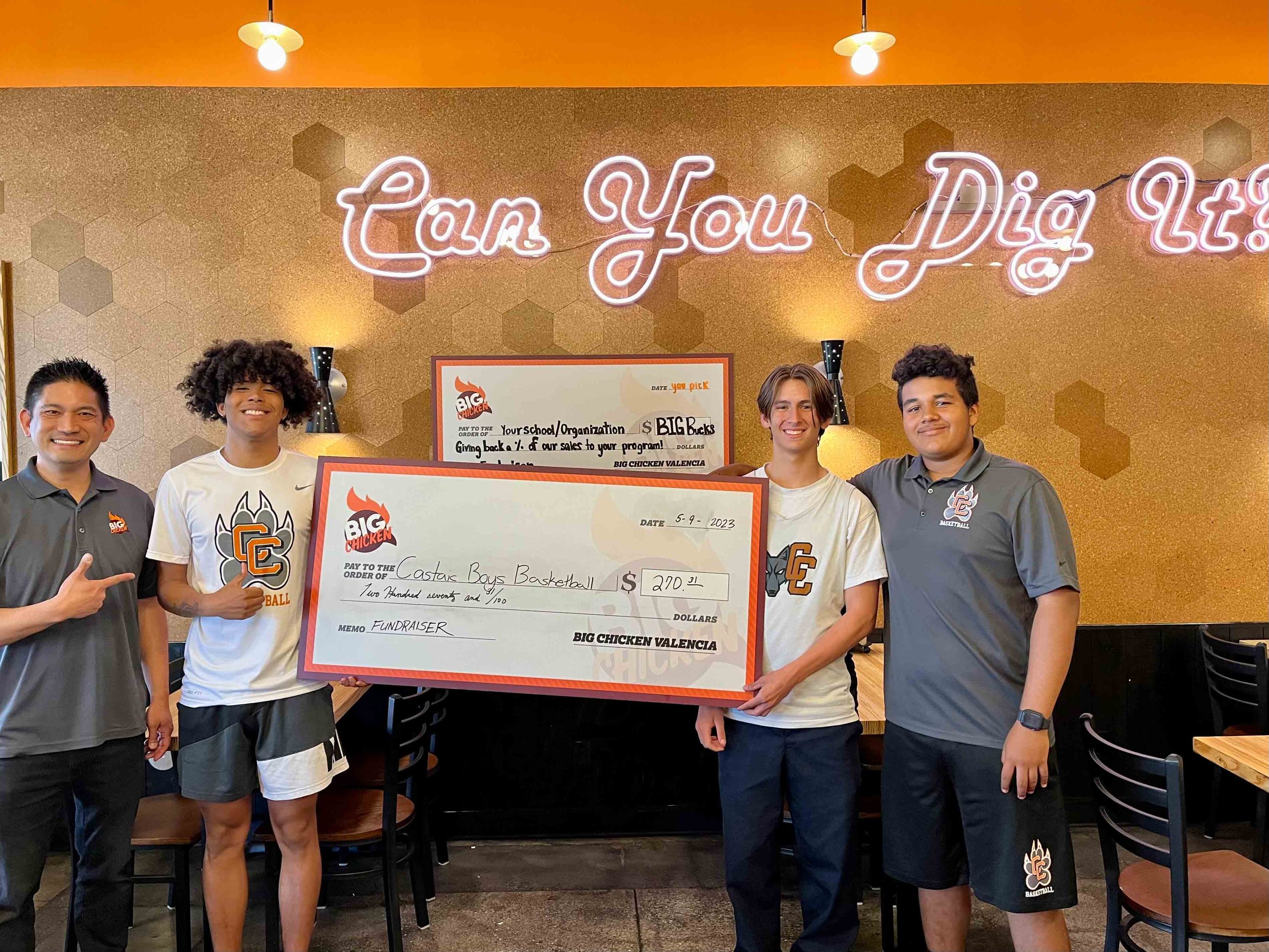 a third image of costas boys basketball team with oversized check donation