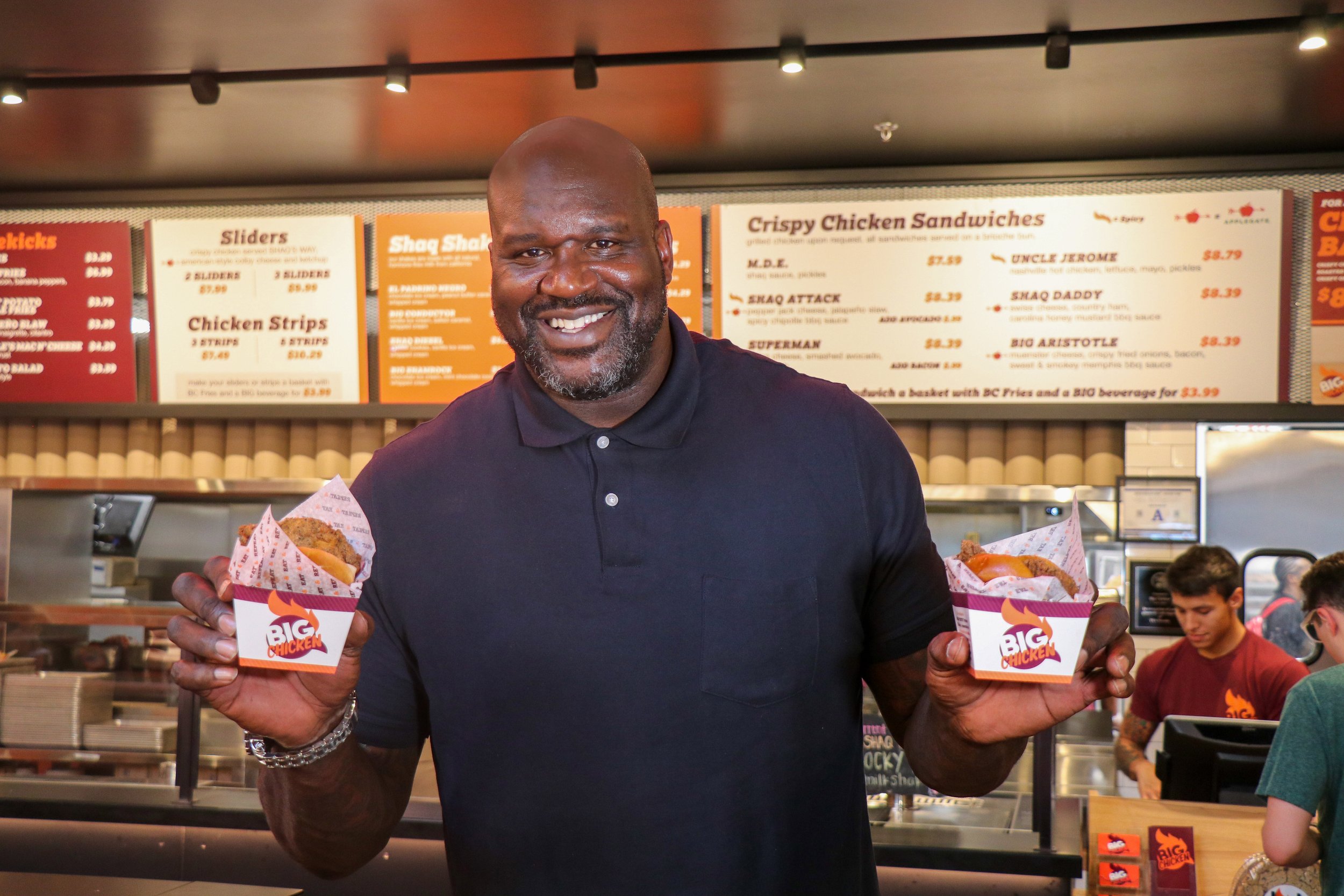 image of Shaquille O'Neal holding two sandwiches inside Big Chicken