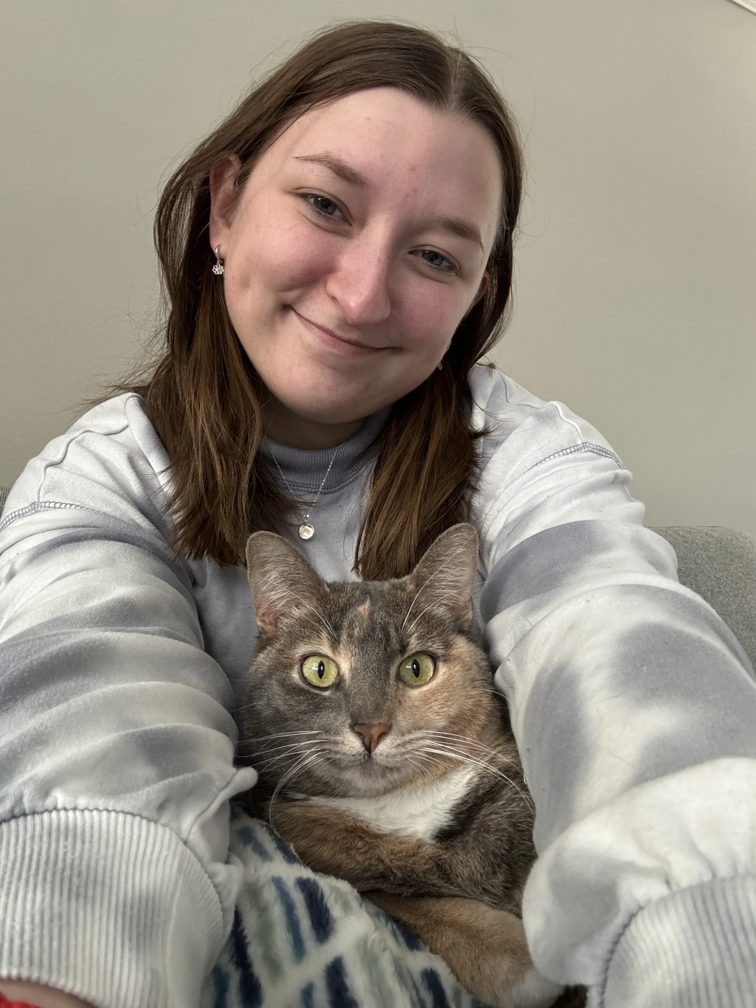 a woman posing with a cat in her lap