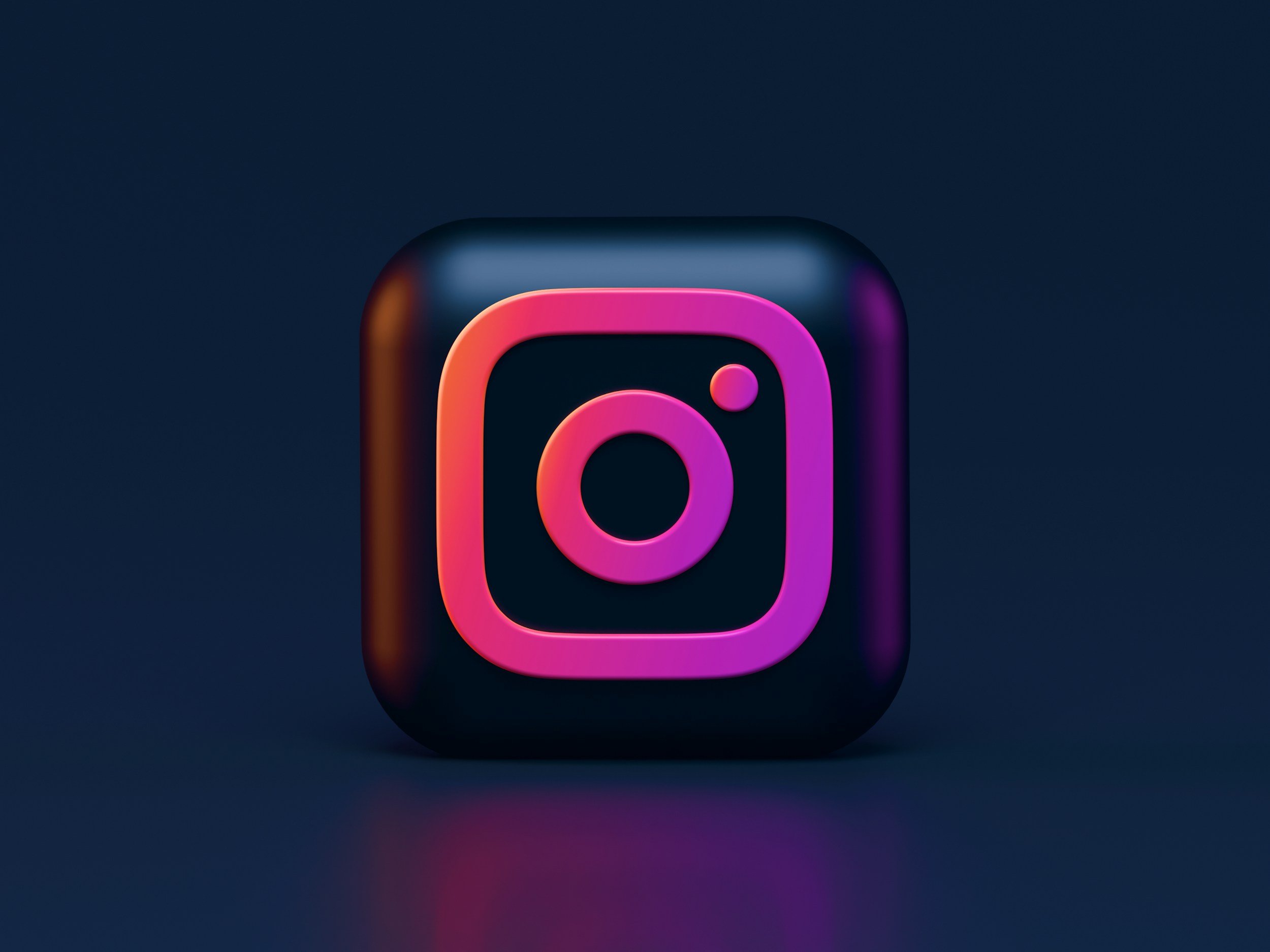 3D digital icon of the Instagram logo with black background and purple-pink glow.