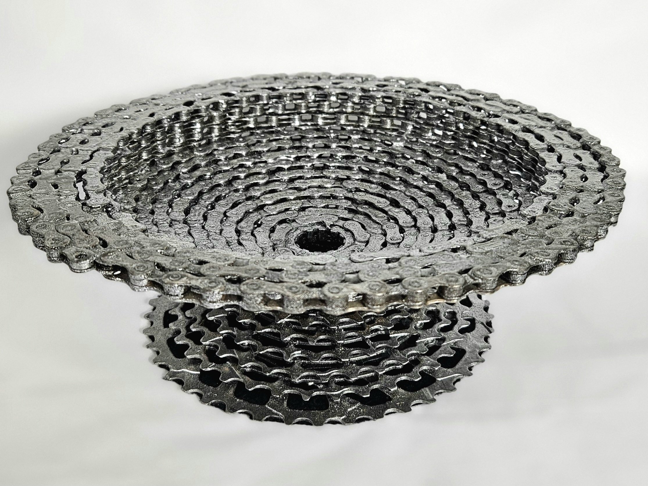 Stacked metal roller chains arranged in a circular pattern.
