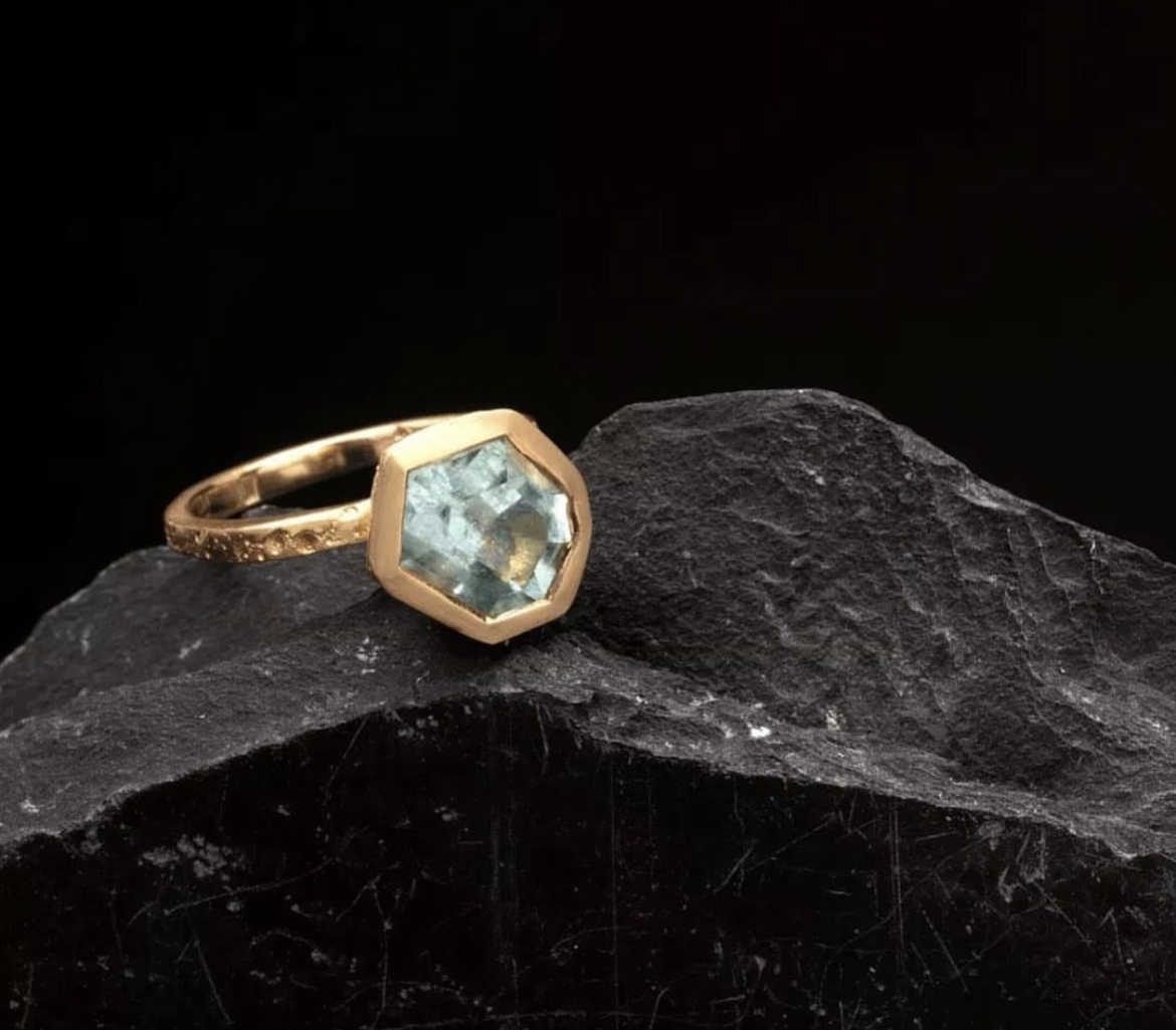 A hand made ring designed by Georgie Brooks featuring a hand cut Australian Aquamarine and recycled 18ct yellow gold