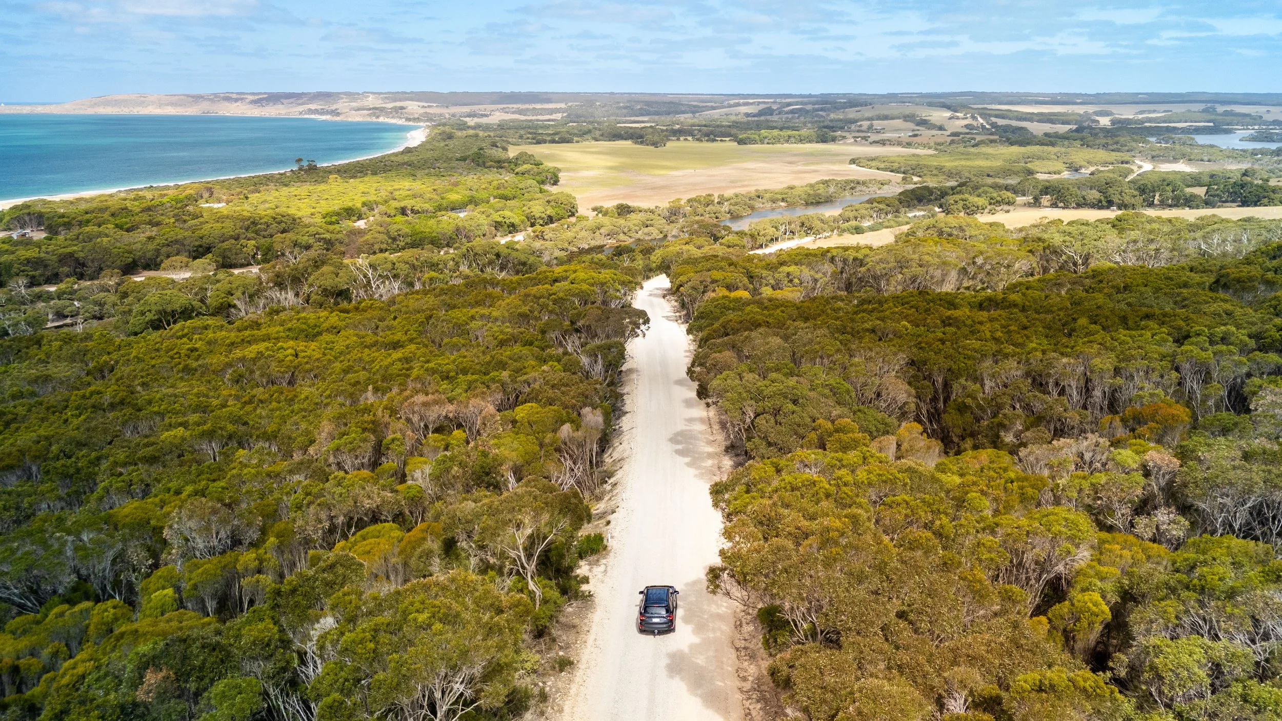 A car driving along a dirt road on Kangaroo Island as part of a private tour
