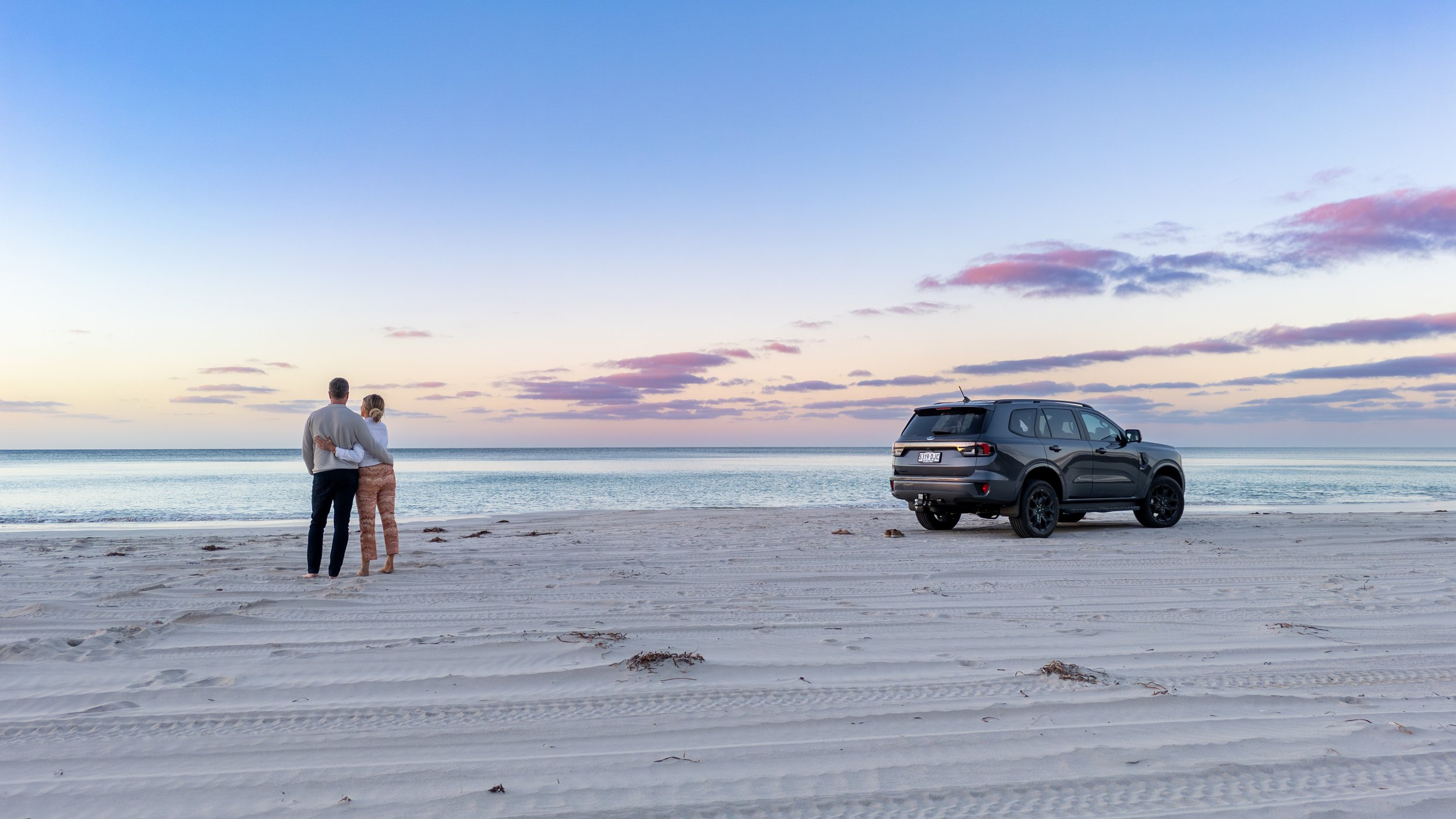 A couple enjoying a tour on Kangaroo Island at Emu Bay beach at sunset