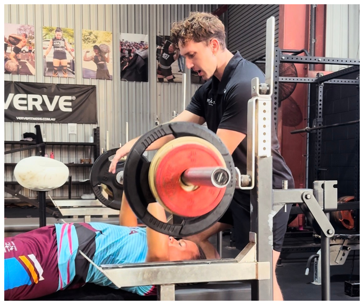A man spotting a woman performing a bench press at a gym.