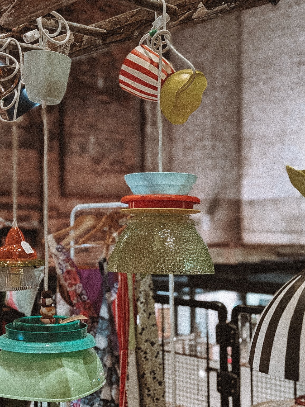 Various colorful lamps hanging from a display rack at a store.