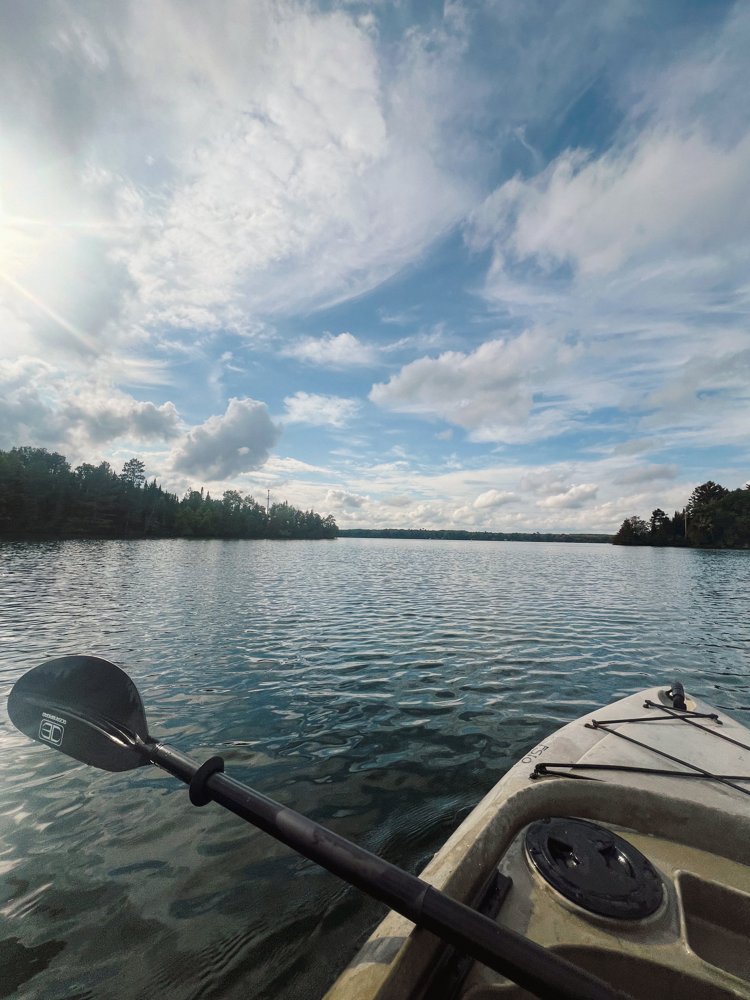 kayaking-pov-calm-lake-outdoor-adventure-nature-photography.jpg
