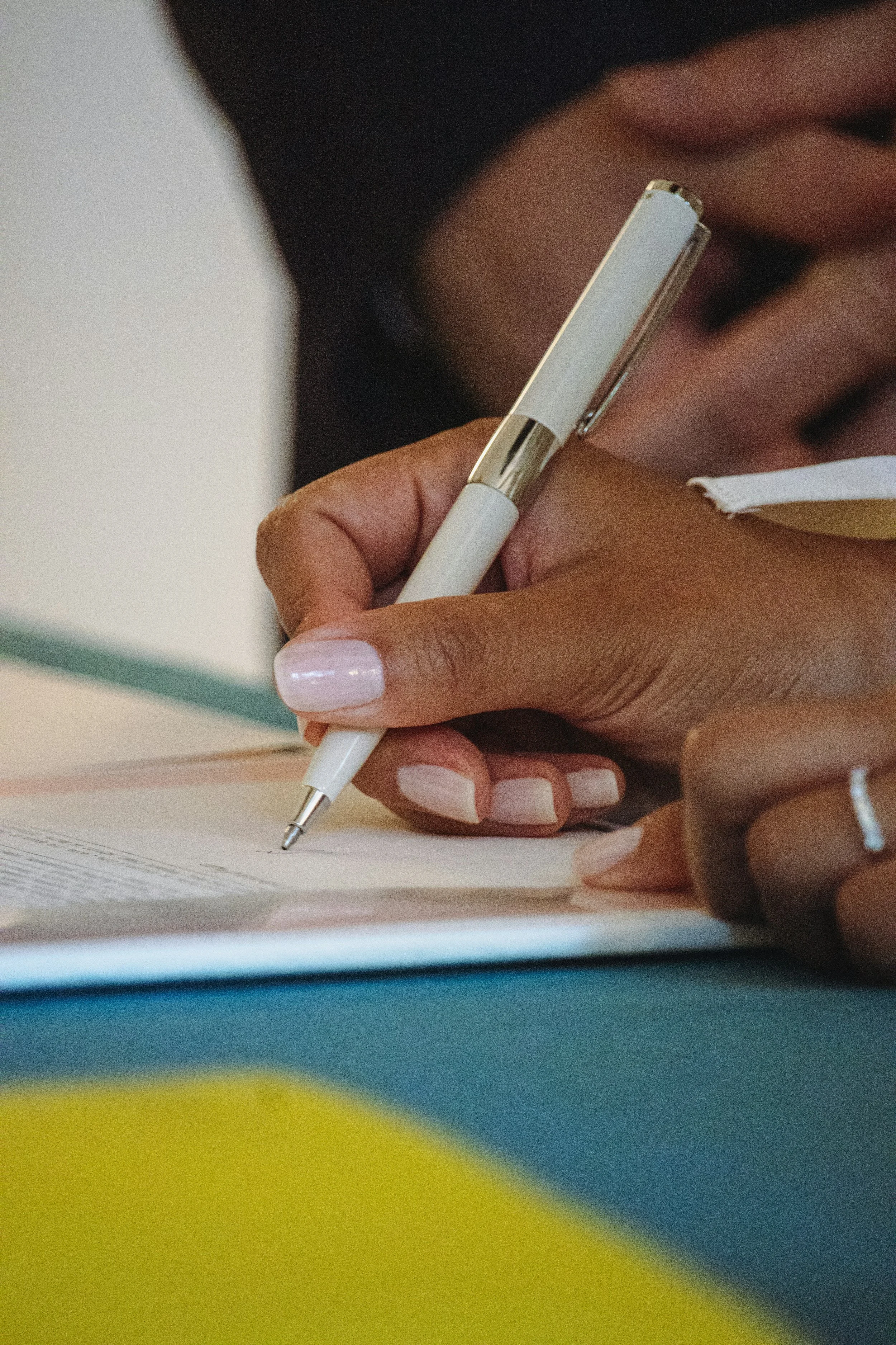 Person signing loan documents with a pen during a loan signing appointment
