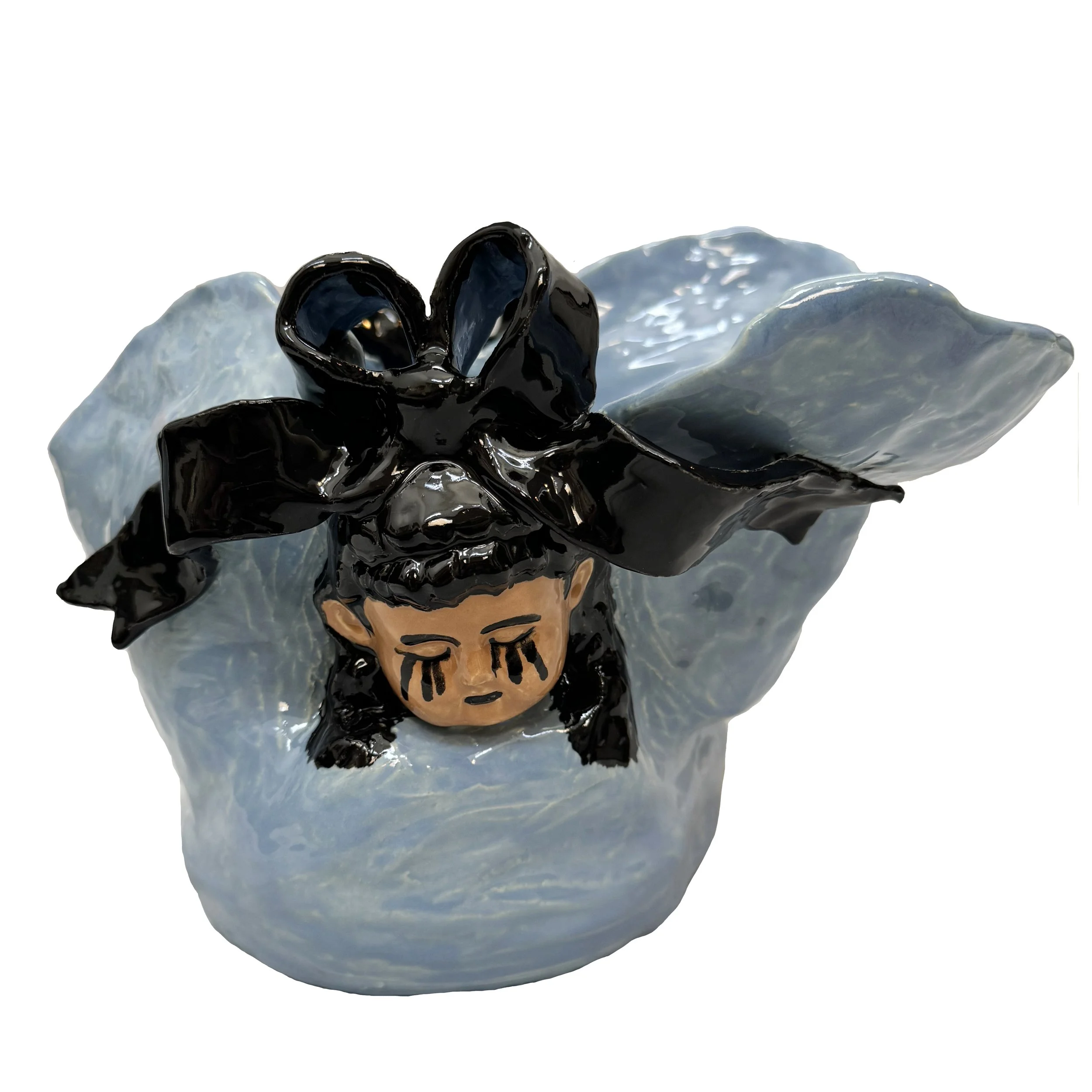 A ceramic sculpture of a sad child with tears on their face, wearing a large black bow and a flowing light blue dress as the pot.