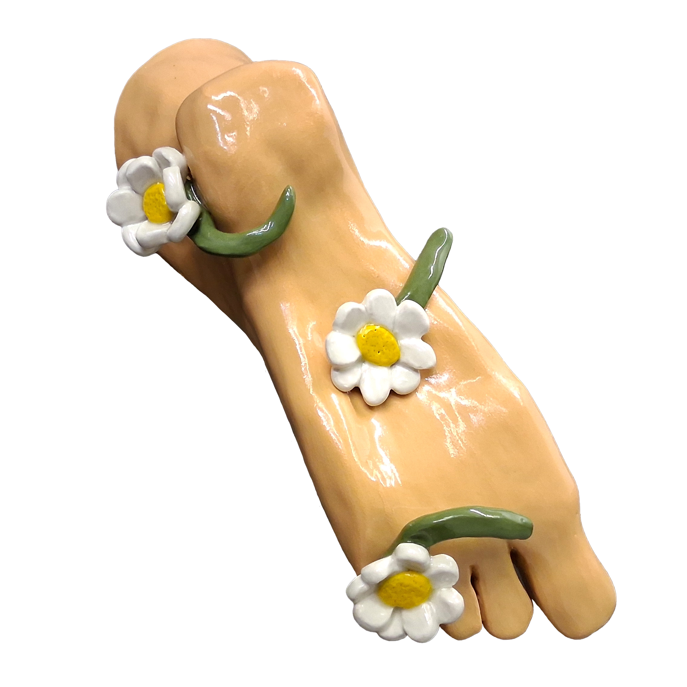A sculptural foot covered in three white daisy flowers with yellow centers and green stems.