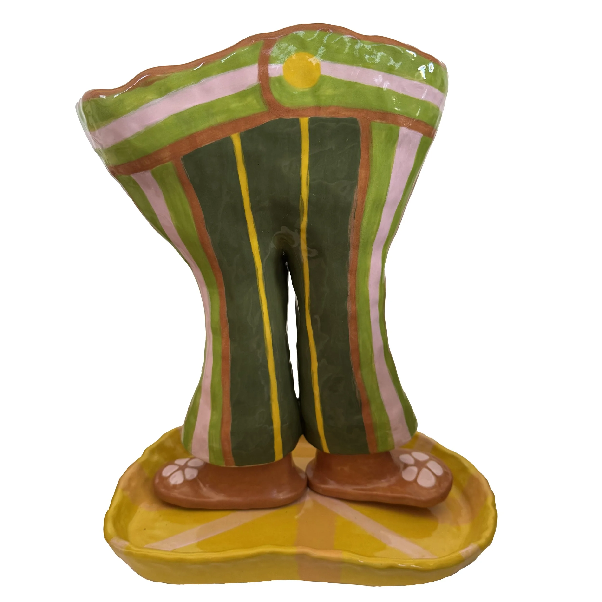 Colorful ceramic statue of a pair of legs in funky striped pants on a yellow base.