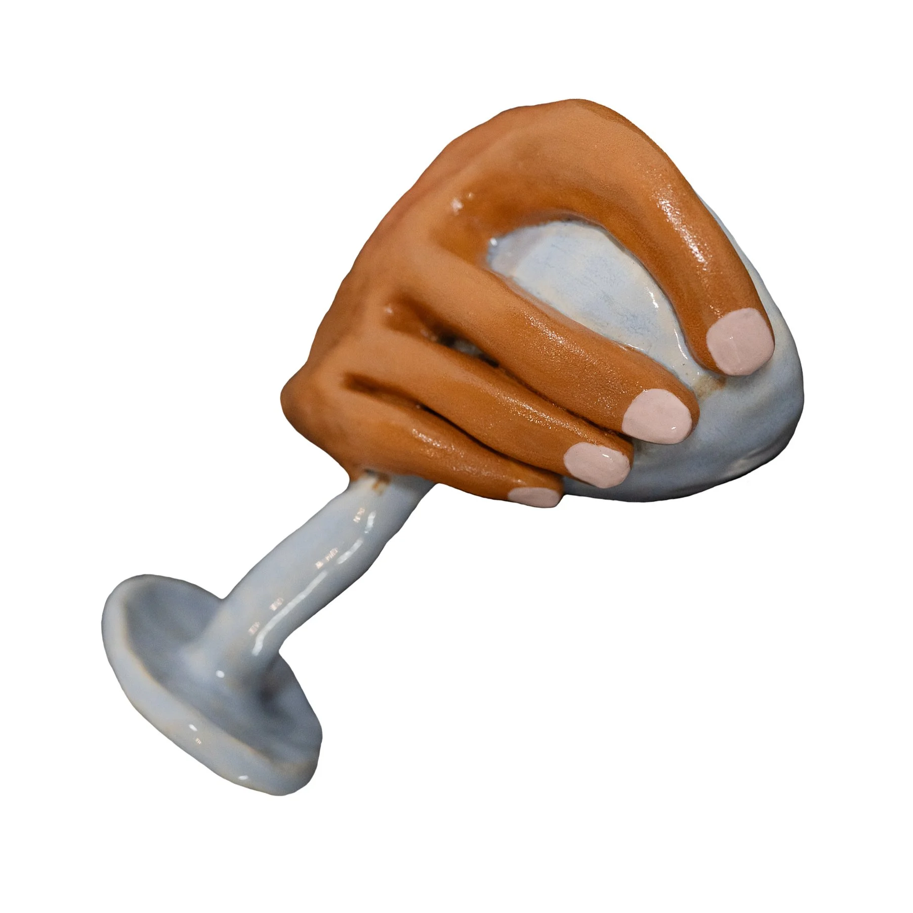A ceramic sculpture of a hand with pink fingernails grasping a light blue wine glass.