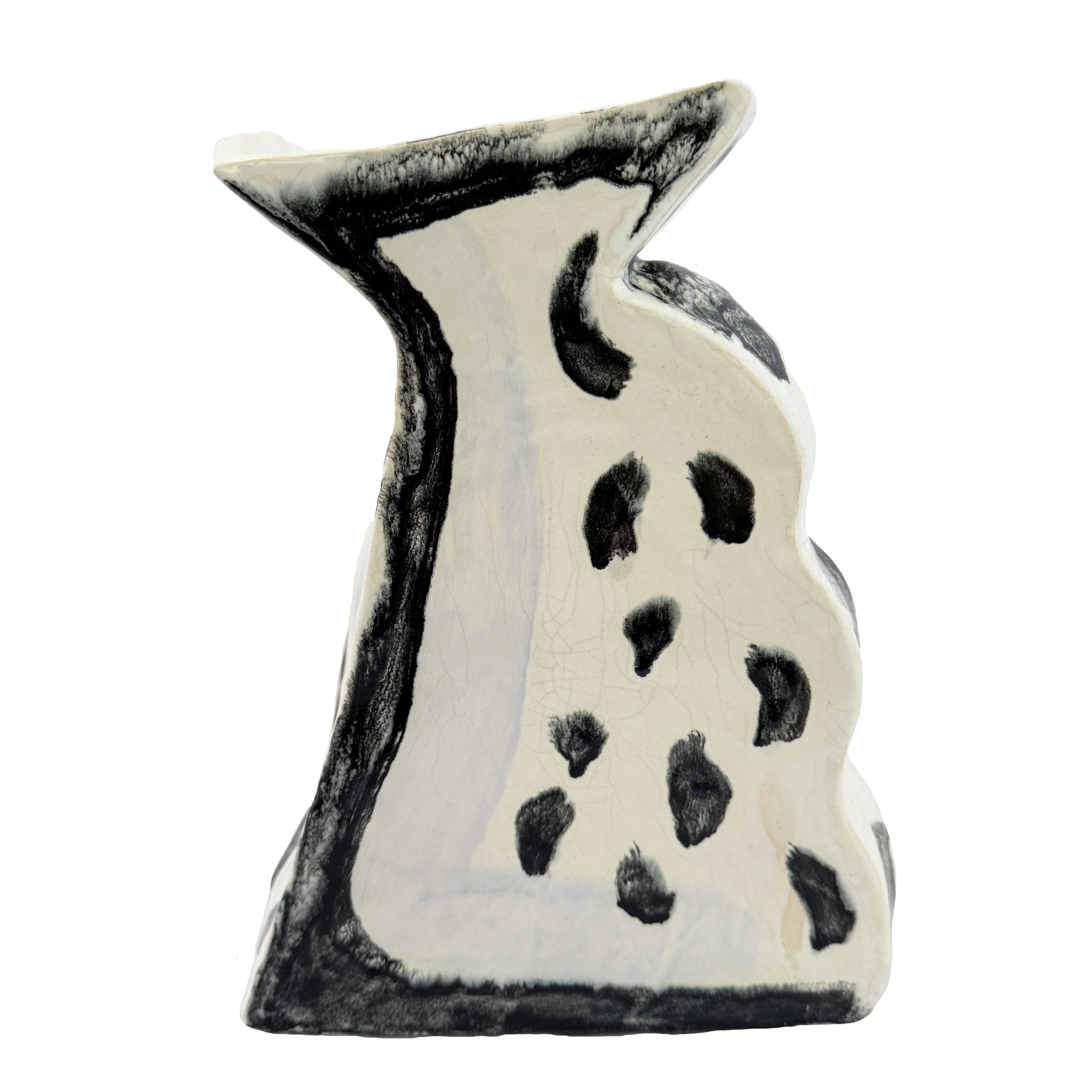Ceramic sculpture resembling a vase, accented with black spots.