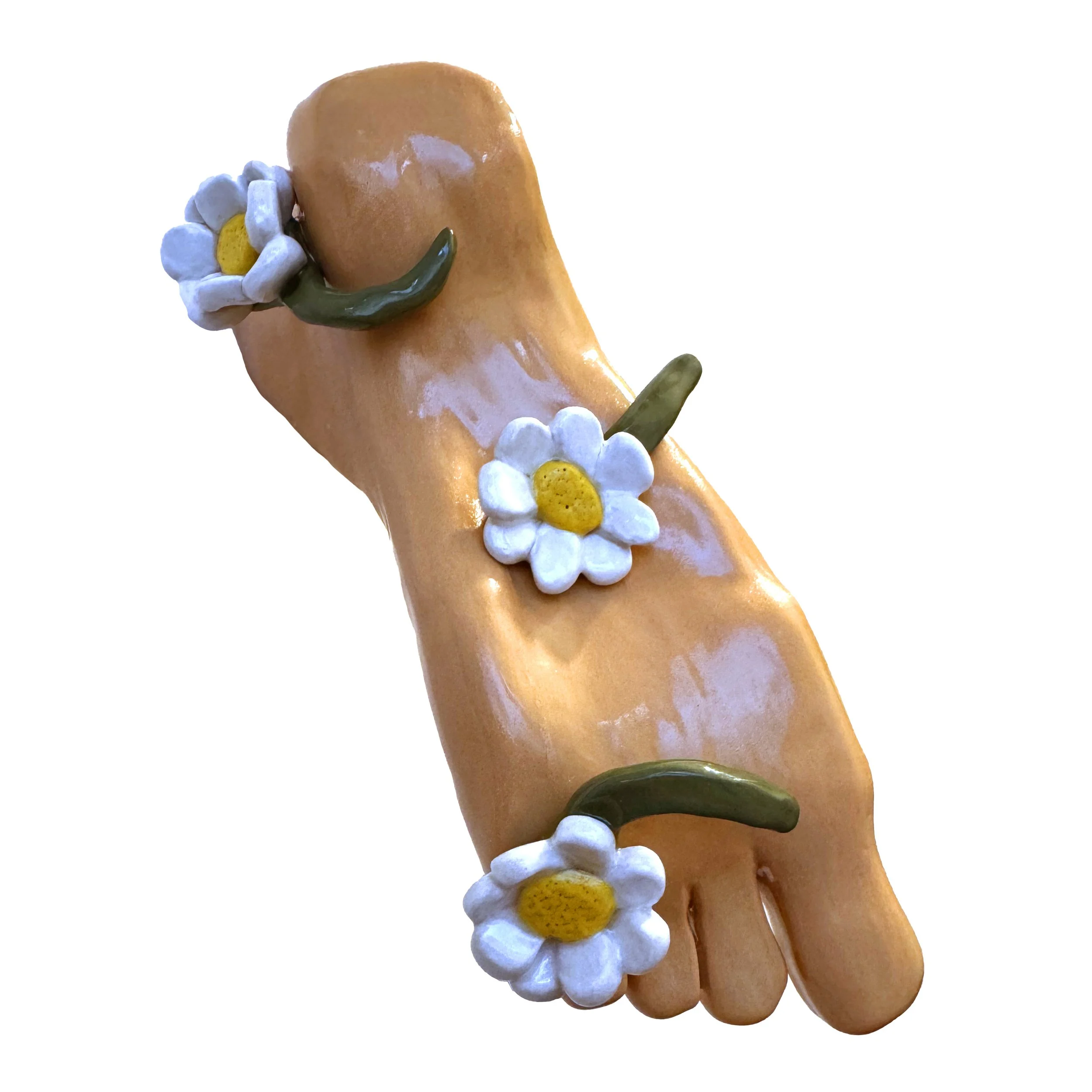 Decorative ceramic sculpture of a human foot with daisies and stems.
