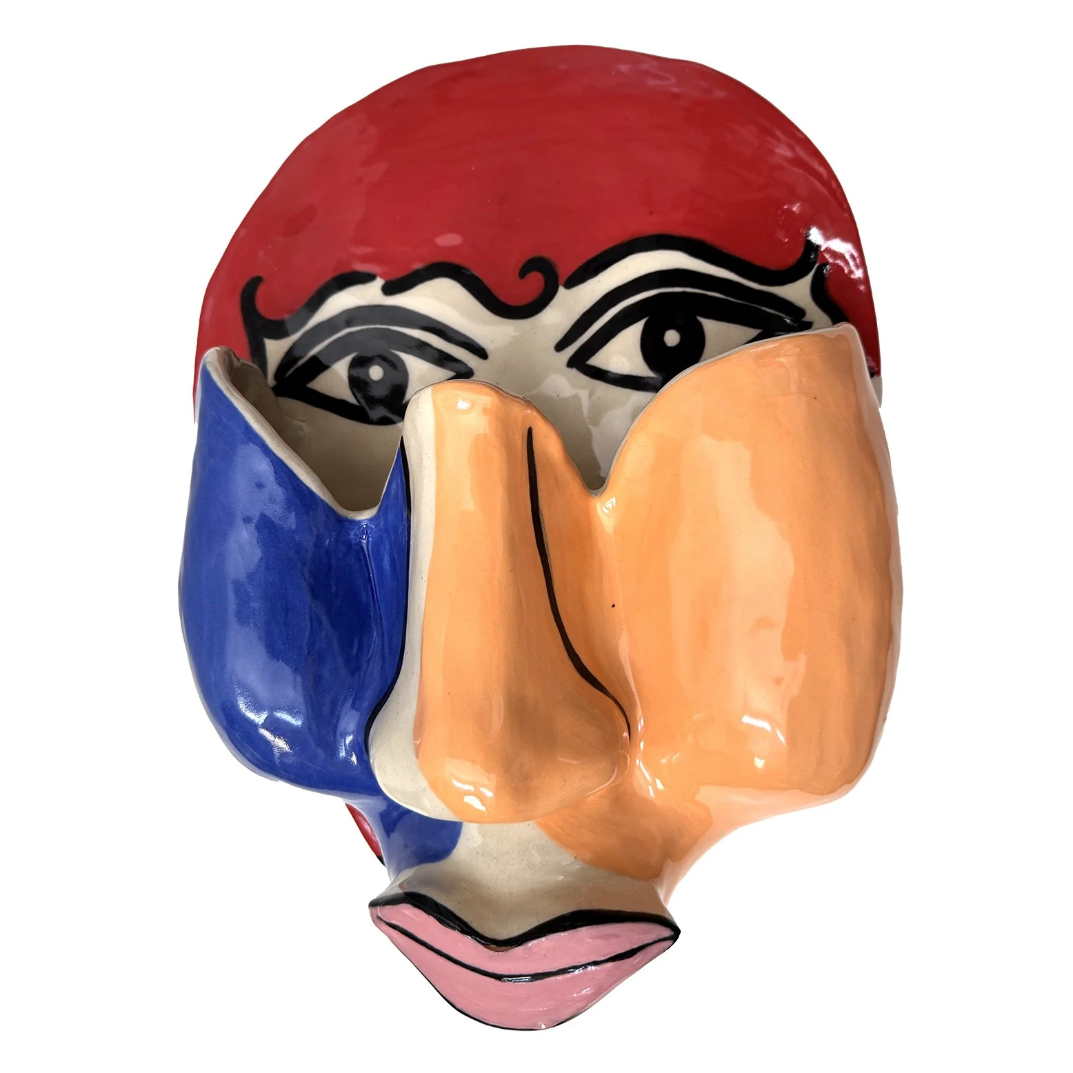 Colorful ceramic sculpture with a painted face, featuring large eyes with dramatic black eyeliner, a red upper section, orange and blue split sections on the face, and pink lips.