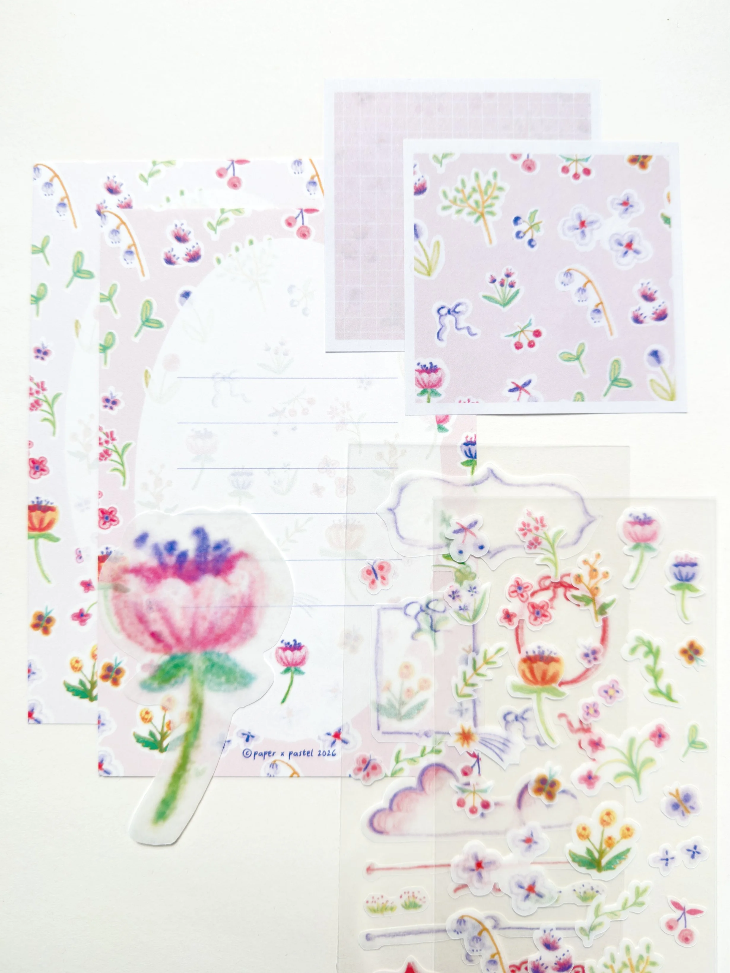 Collection of floral and nature-themed stickers, decorative paper, and cutouts featuring flowers, leaves, butterflies, and clouds in pastel colors.