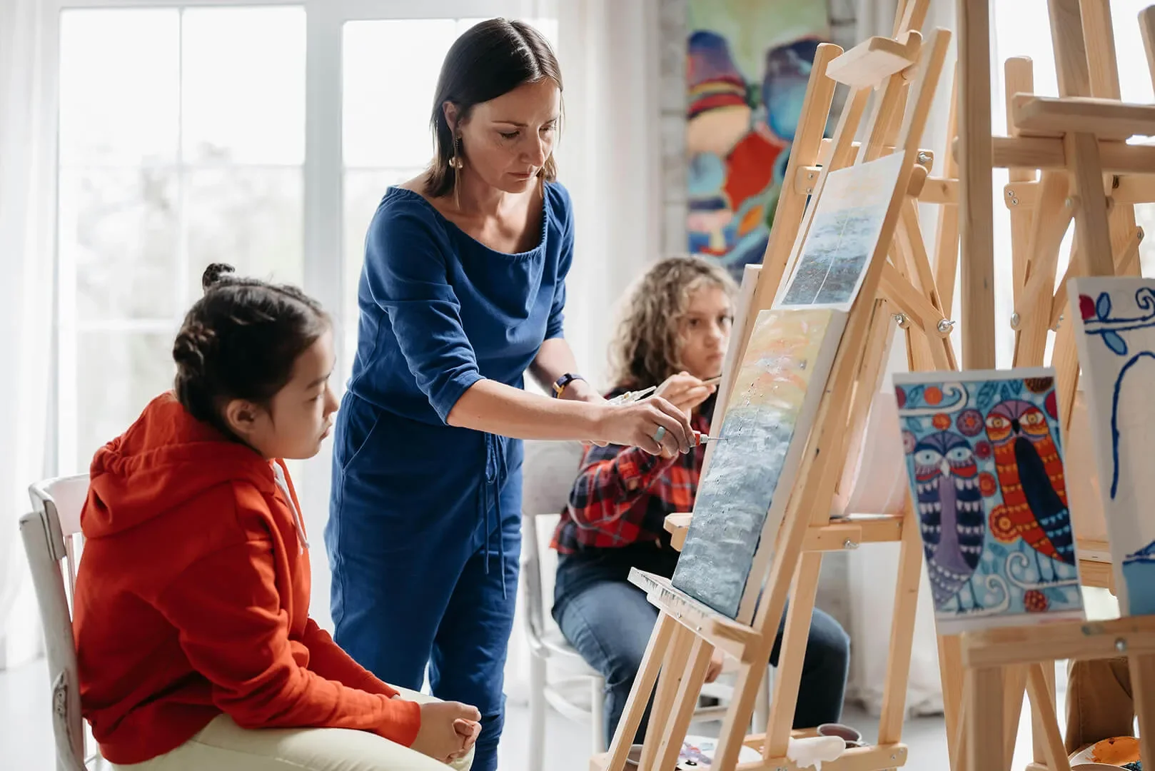 Children learning painting technique in art class
