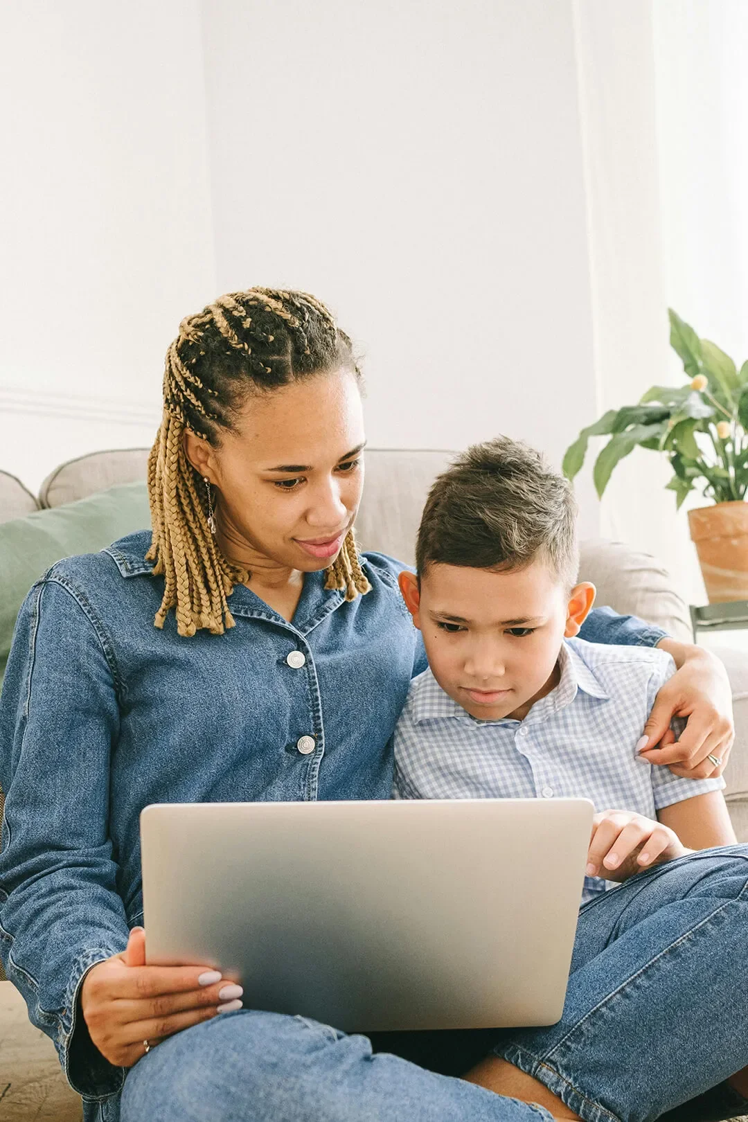 Mother and son at home on laptop together.