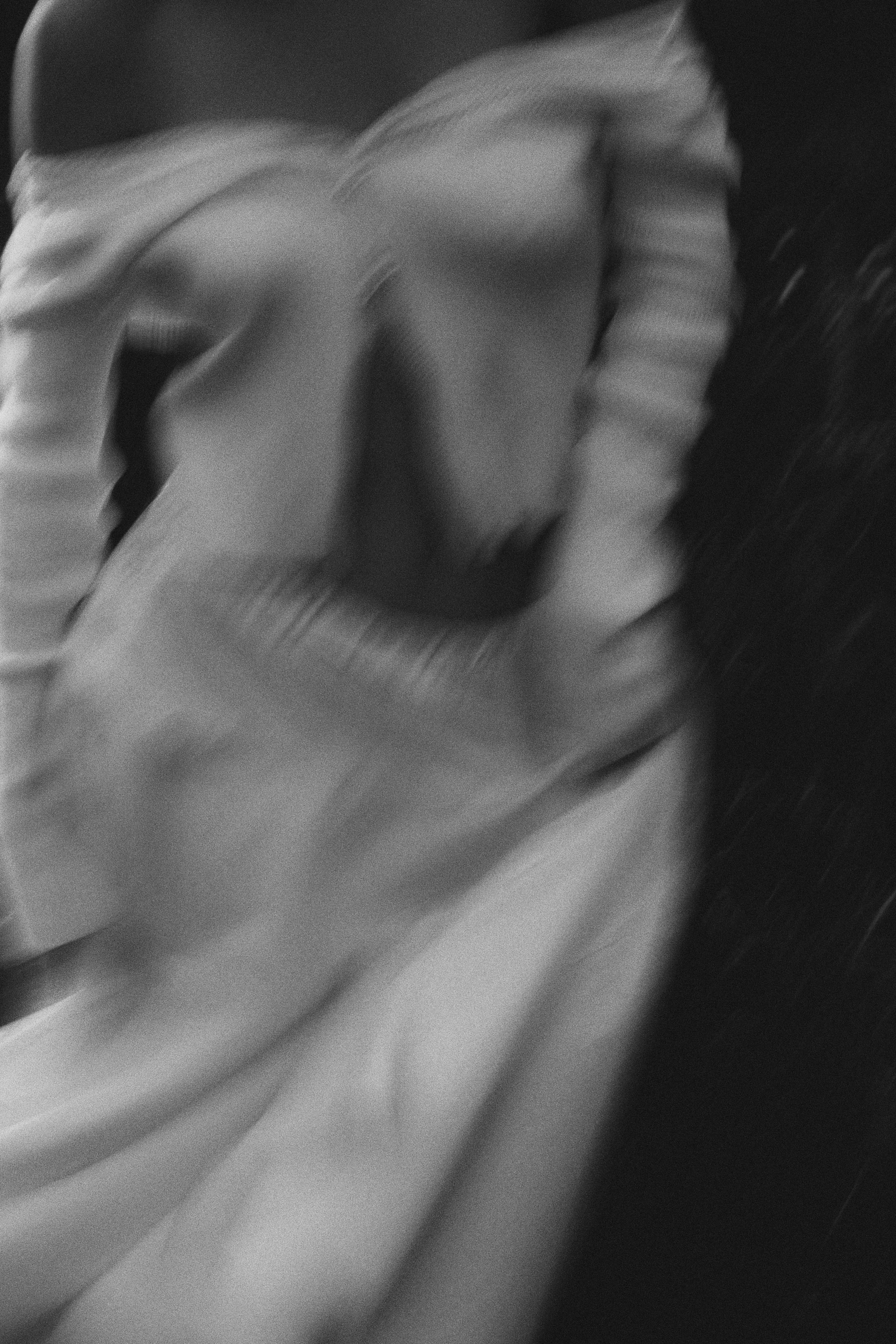 A person adjusting their sleeve in a black and white photo.