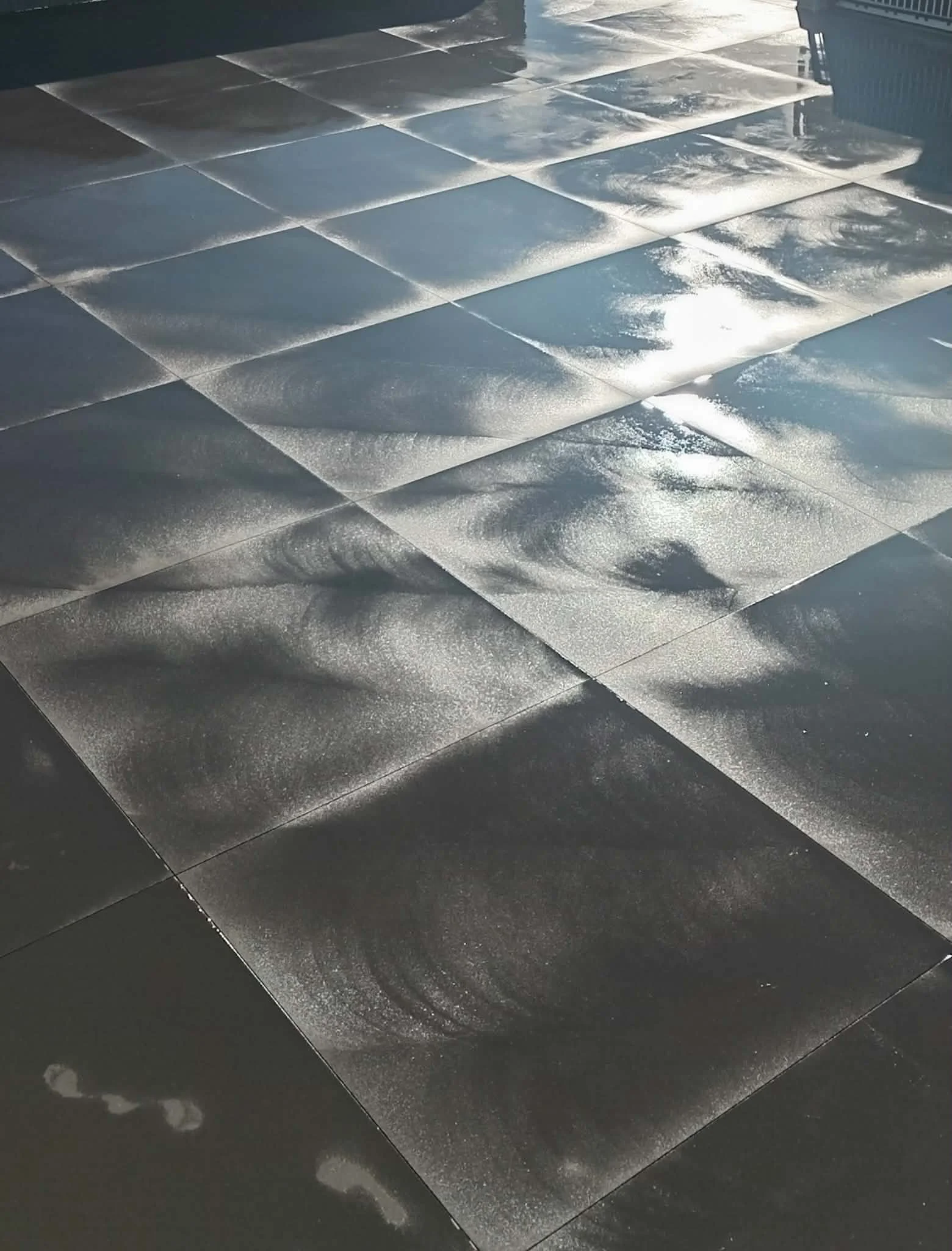 Floor tiles with a frosted or icy appearance reflecting sunlight.