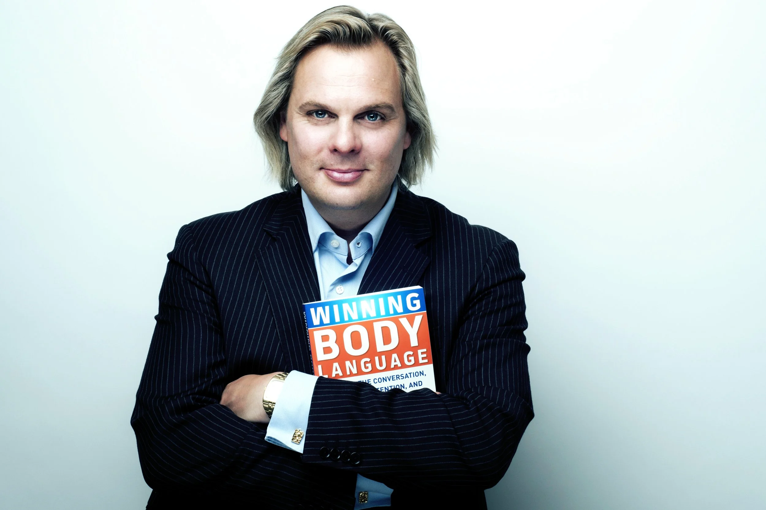 Mark Bowden holding his book, Winning Body Language.