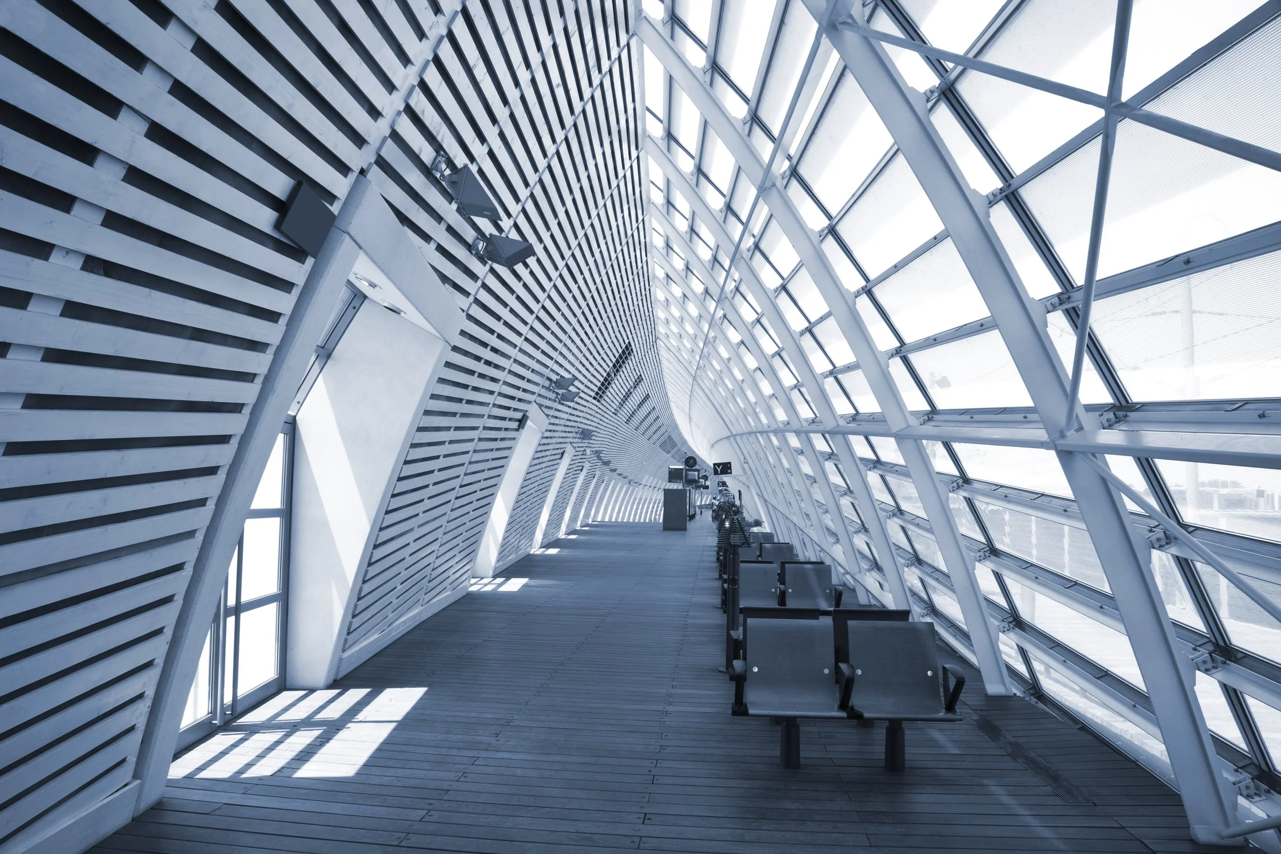 Bright airport terminal corridor with seating and large windows