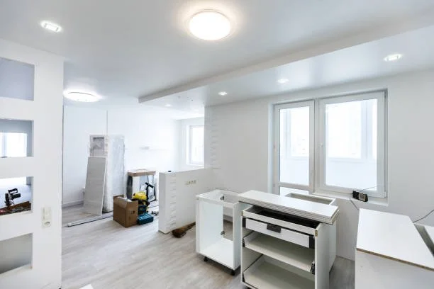 Moderner, heller Wohnraum während Renovierung mit Bauwerkzeugen, Möbeln und Baumaterialien