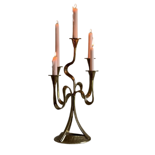 A brass chandelier with five lit candles.
