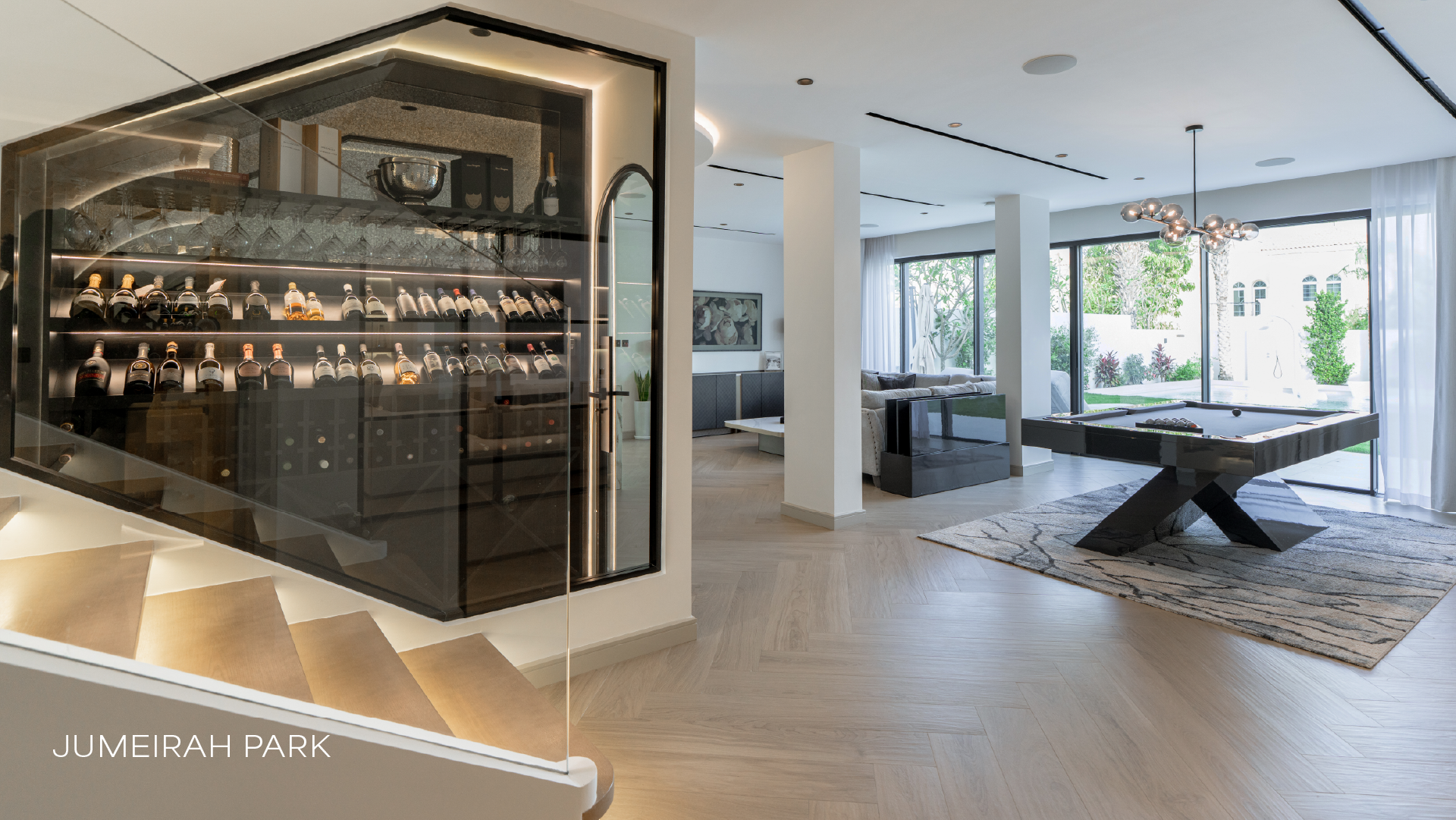 Glass-enclosed wine room in Jumeirah Park villa with open-plan living area and garden views