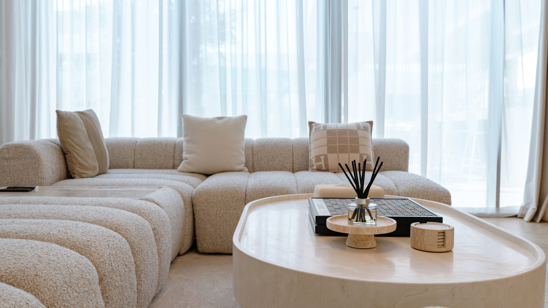 Neutral living-room seating with a sculptural coffee table and soft furnishings in a Dubai villa.