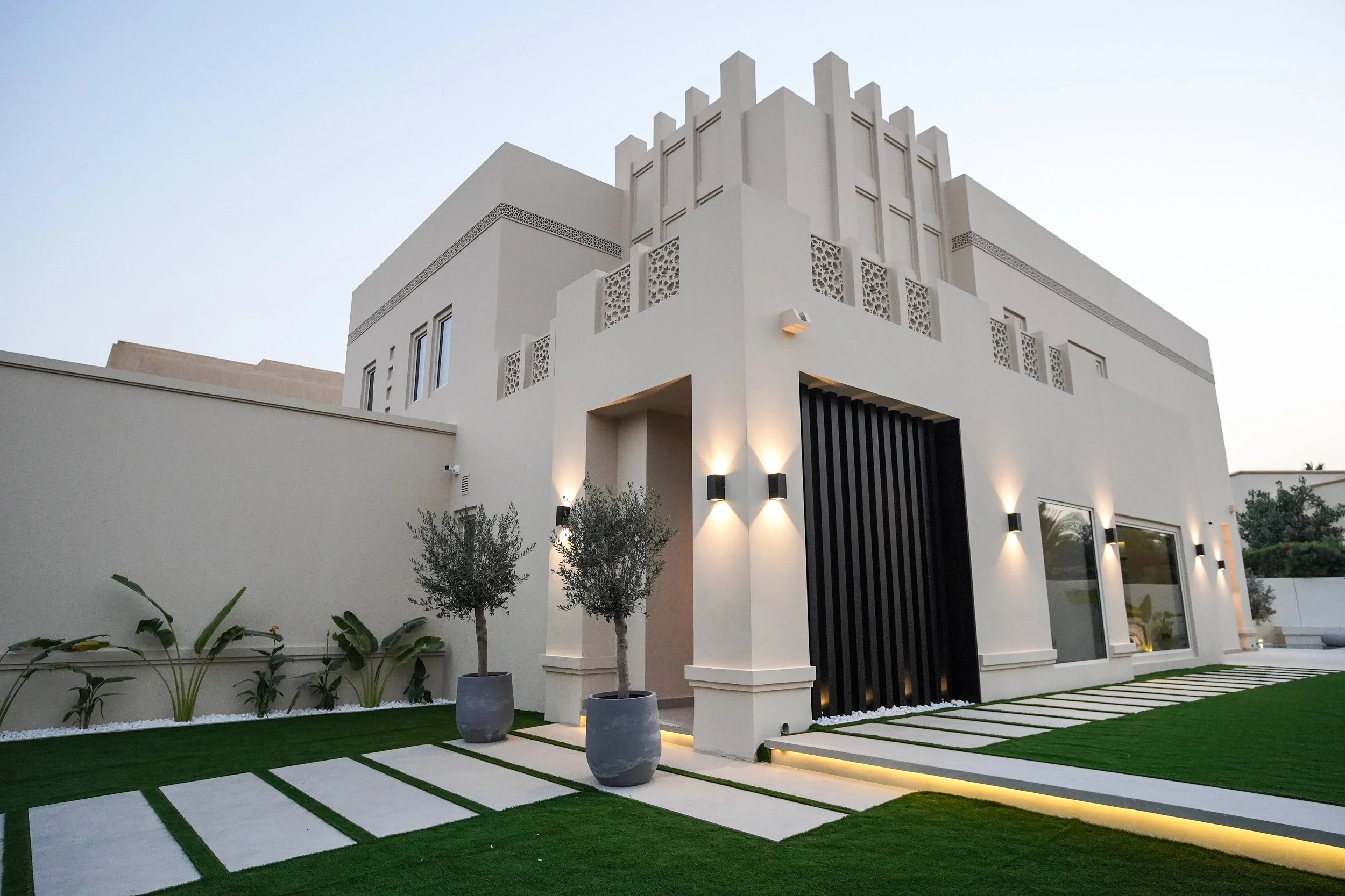 Al Mahra Arabian Ranches villa garden with stepping-stone pathway, lawn, planting and outdoor seating area.