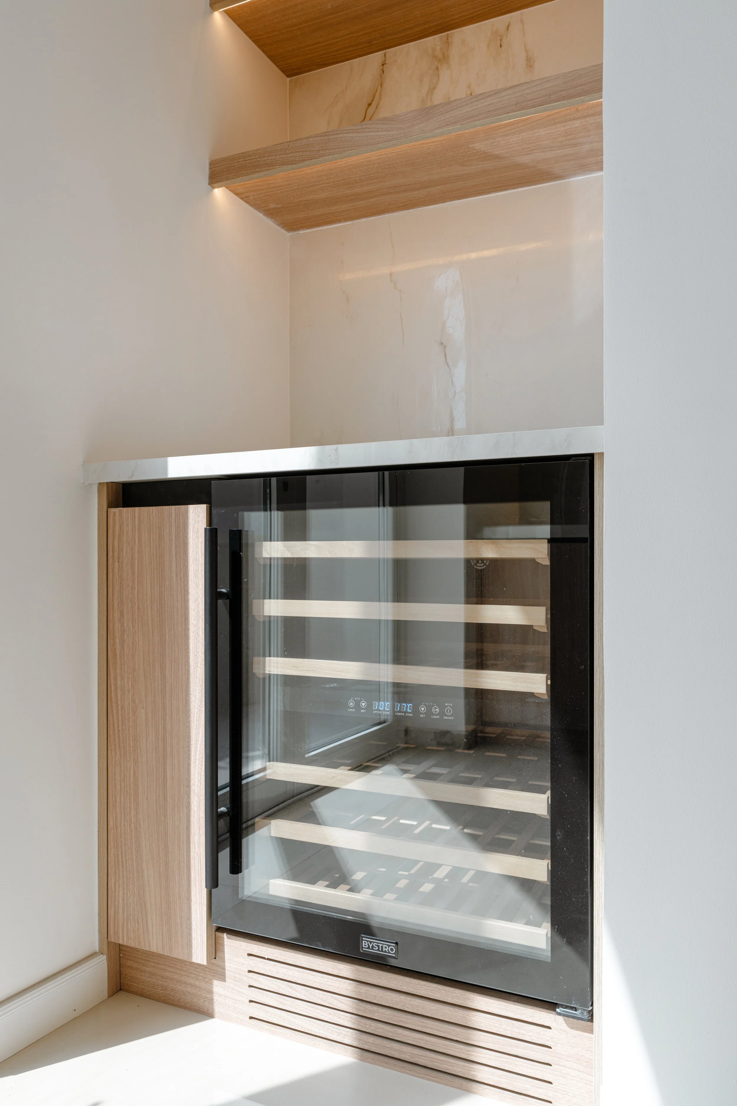 Integrated wine fridge and custom kitchen cabinetry detail in an Al Reem 1 villa renovation.
