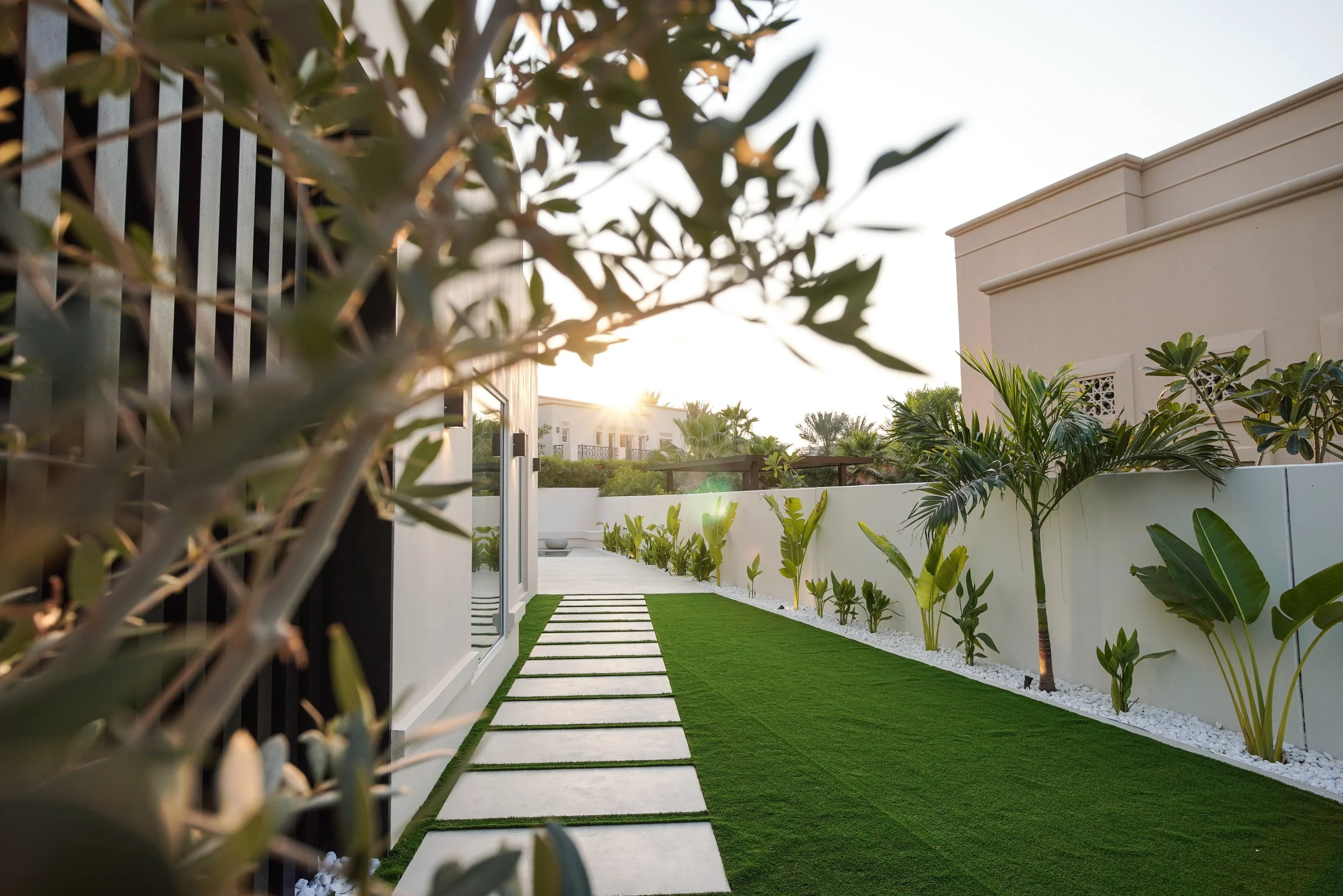 Al Mahra Arabian Ranches villa garden with stepping-stone pathway, lawn, planting and outdoor seating area.