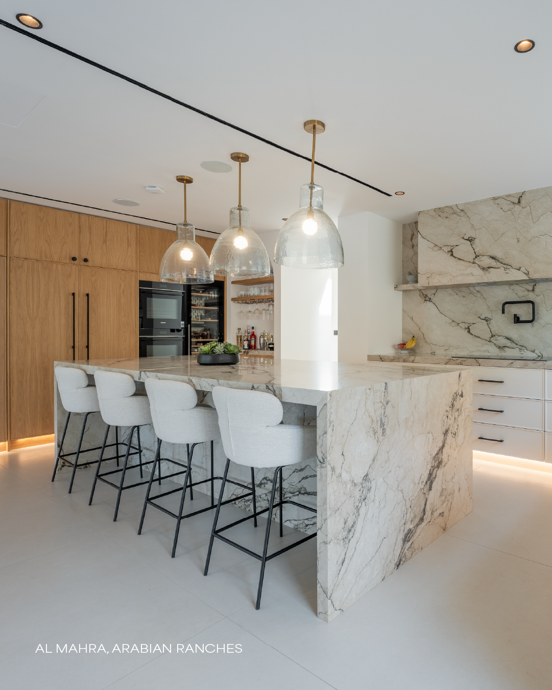 Luxury villa kitchen in Al Mahra, Arabian Ranches with island, cabinetry, pendant lights and bar seating